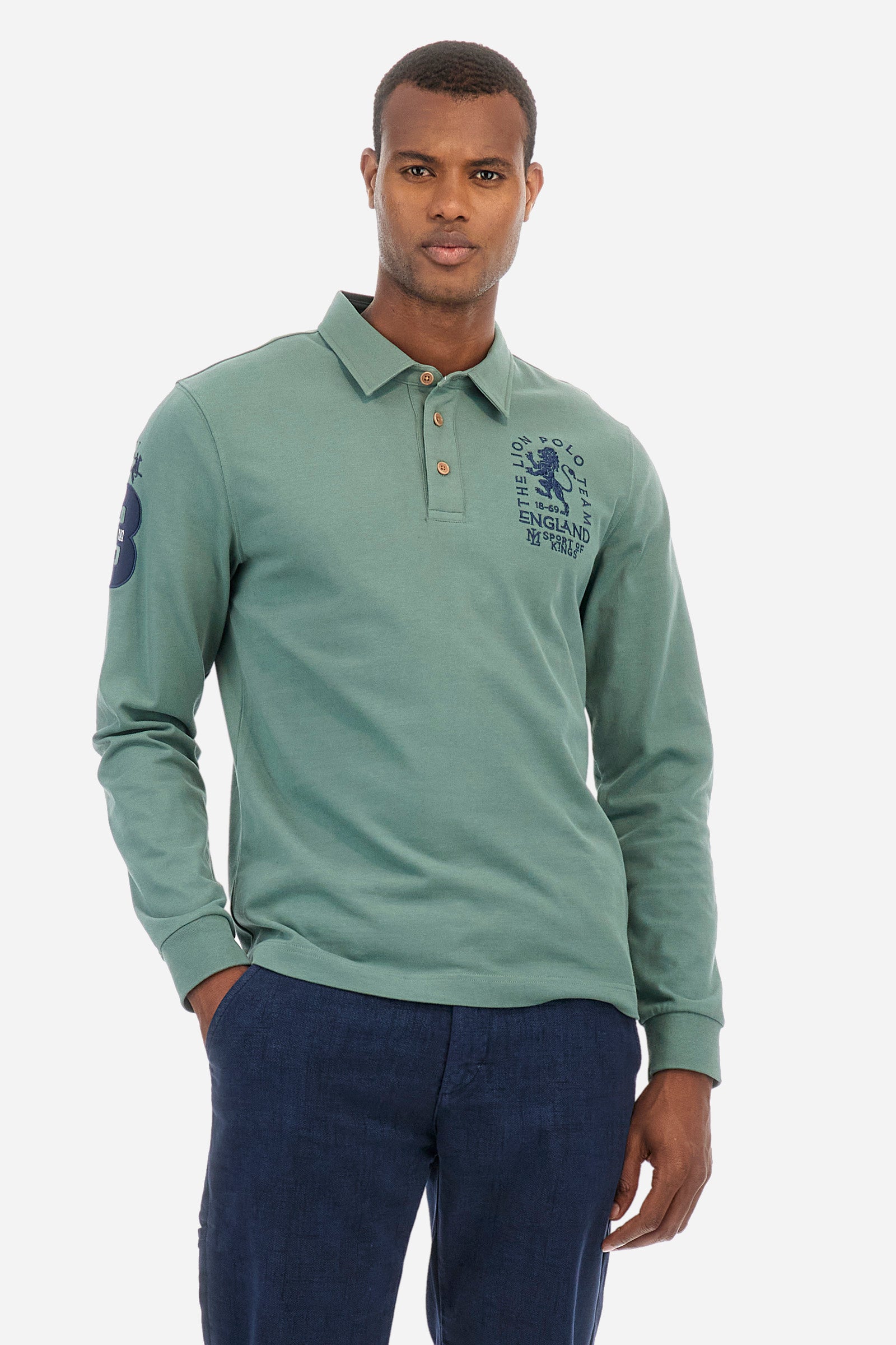 Men's plain short-sleeved polo shirt, made from 100% cotton. Three-button fastening. One of the sleeves features a patch depicting the number 3 and the brand logo. The front is finished with symbols and lettering associated with the England line. Regular fit. The model is wearing a size L. - Laurel Wreath