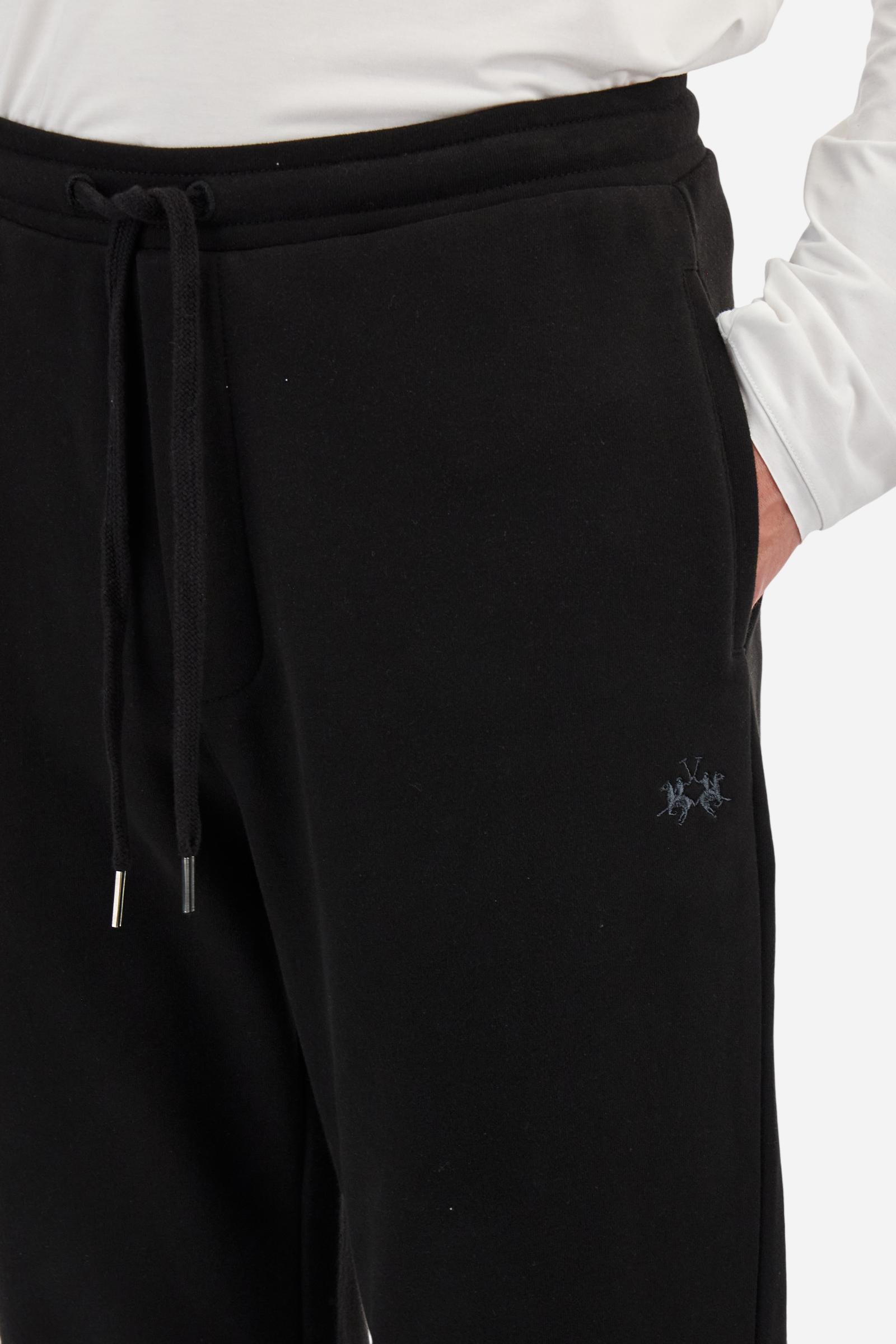 Single-colour men's jogging trousers in a French terry cotton sweat fabric. Removable and adjustable waistband with drawstring. American pockets at the sides. An additional patch pocket is applied on the back. The logo is embroidered in a colour-contrasting thread on the front, left side. The fit is regular. The model is wearing a size L. - Black