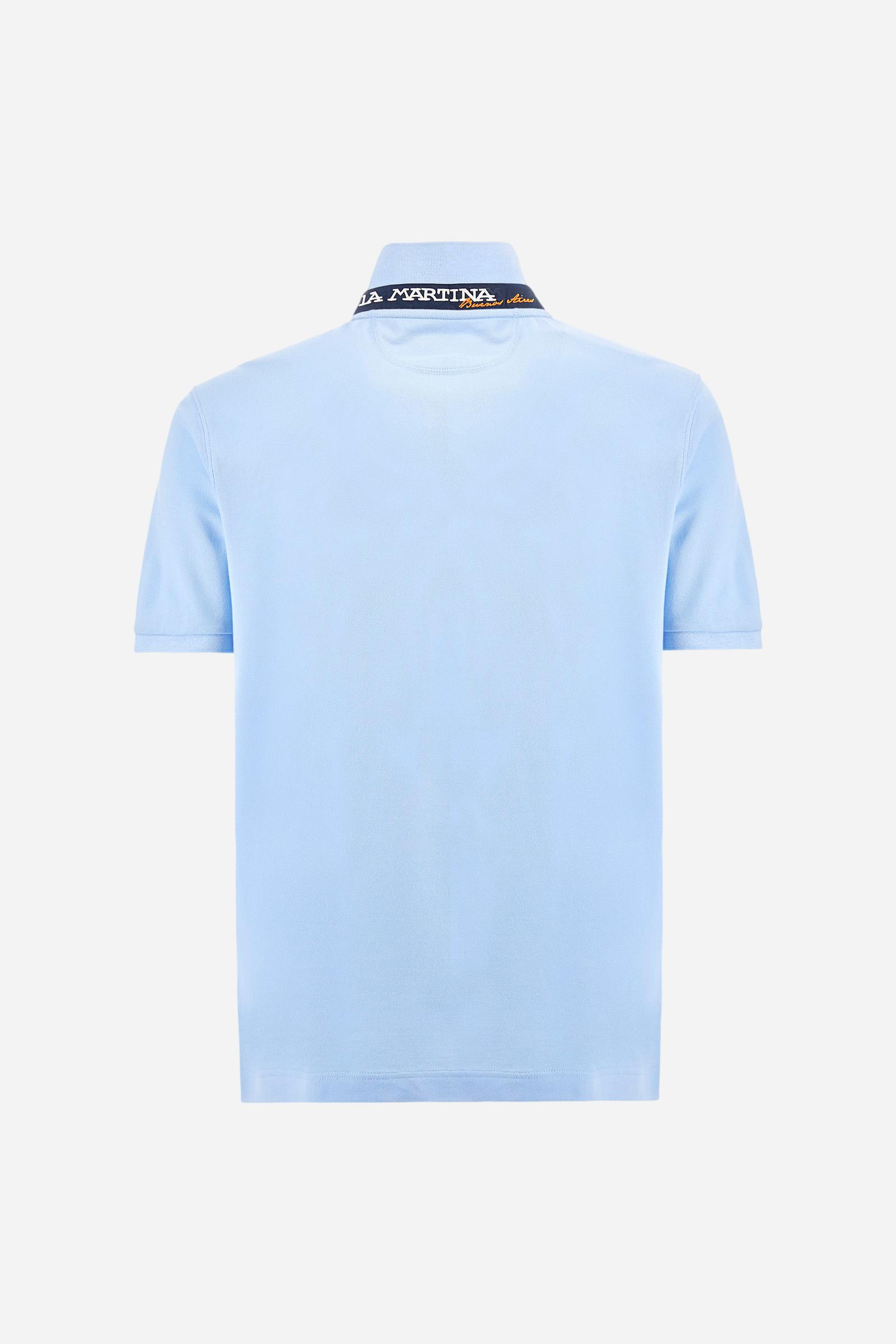 Men's plain short-sleeved polo shirt made from stretch piqué. Two-button fastening. The collar and cuffs are made from tone-on-tone ribbed fabric. Under the collar, there is a contrasting fabric panel with embroidered multicoloured lettering. The logo is embroidered on the left side of the chest in contrasting thread. Slim fit. The model is wearing a size L. - Vista Blue