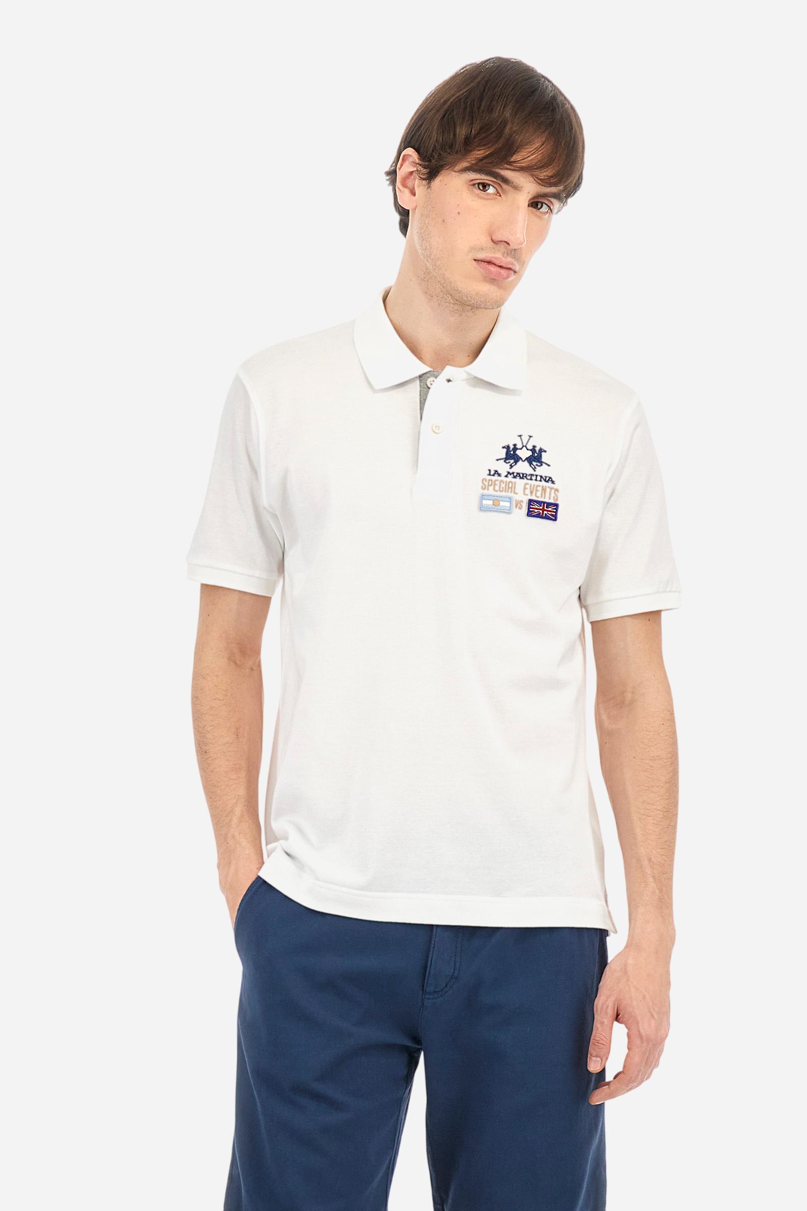 Men's plain short-sleeved polo shirt made from cotton piqué. Two-button fastening. The collar and cuffs are made from tone-on-tone ribbed fabric. The inside of the placket is also made from piqué, but in a contrasting colour. On the left side of the chest, in addition to the embroidered logo in contrasting thread, there are small patches of the Argentine and English flags. Regular fit. The model is wearing a size L. - Optic White