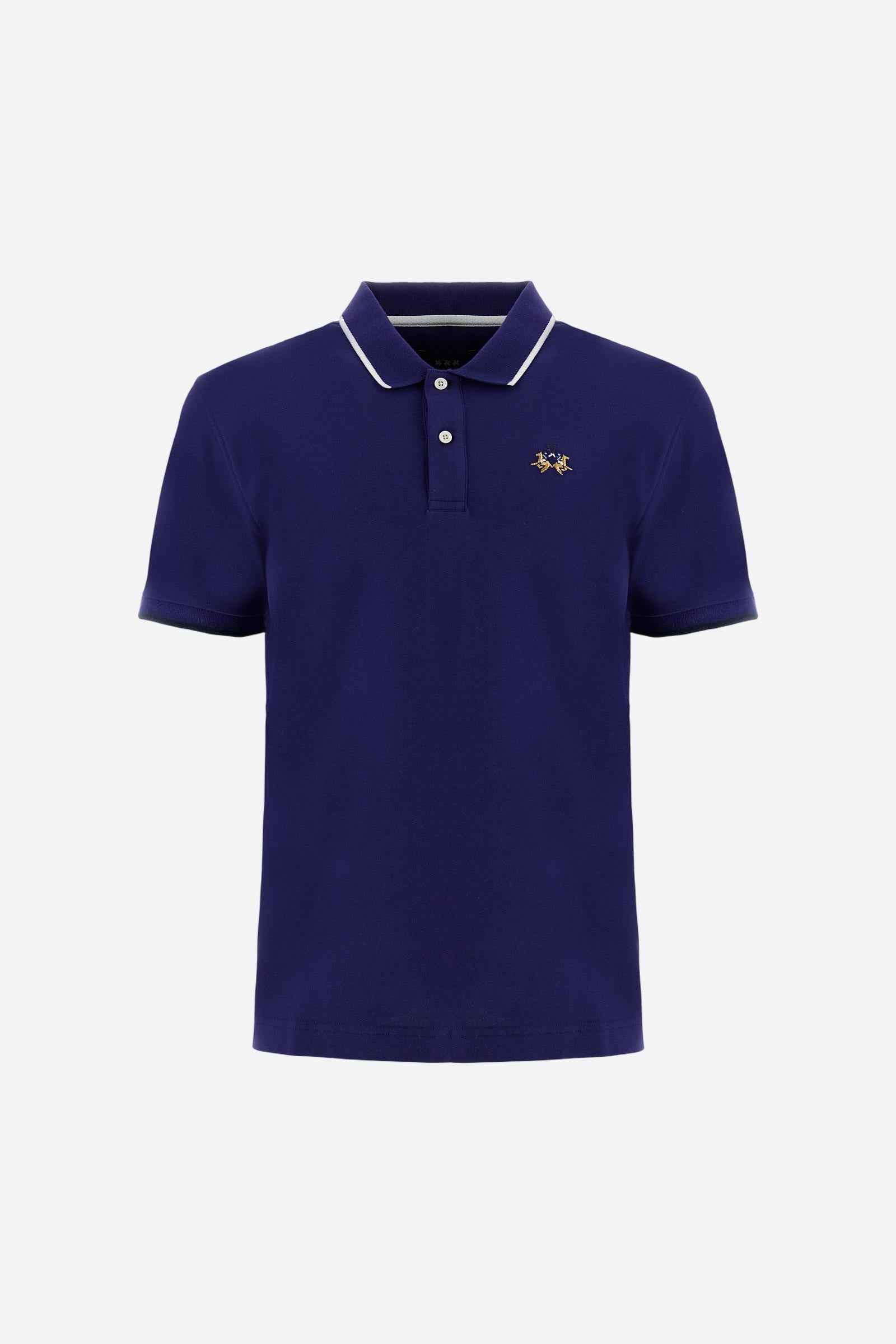 Short-sleeved, single-colour men's polo shirt made of stretch cotton piqué. Fastens with two buttons. The collar and cuffs are ribbed, and there is a colour-contrasting trim at the bottom of the collar. Inside the collar there is a grosgrain ribbon of a different shade. The logo is embroidered on the chest in a contrasting colour. The fit is slim. The model is wearing a size L. - Deep Cobalt