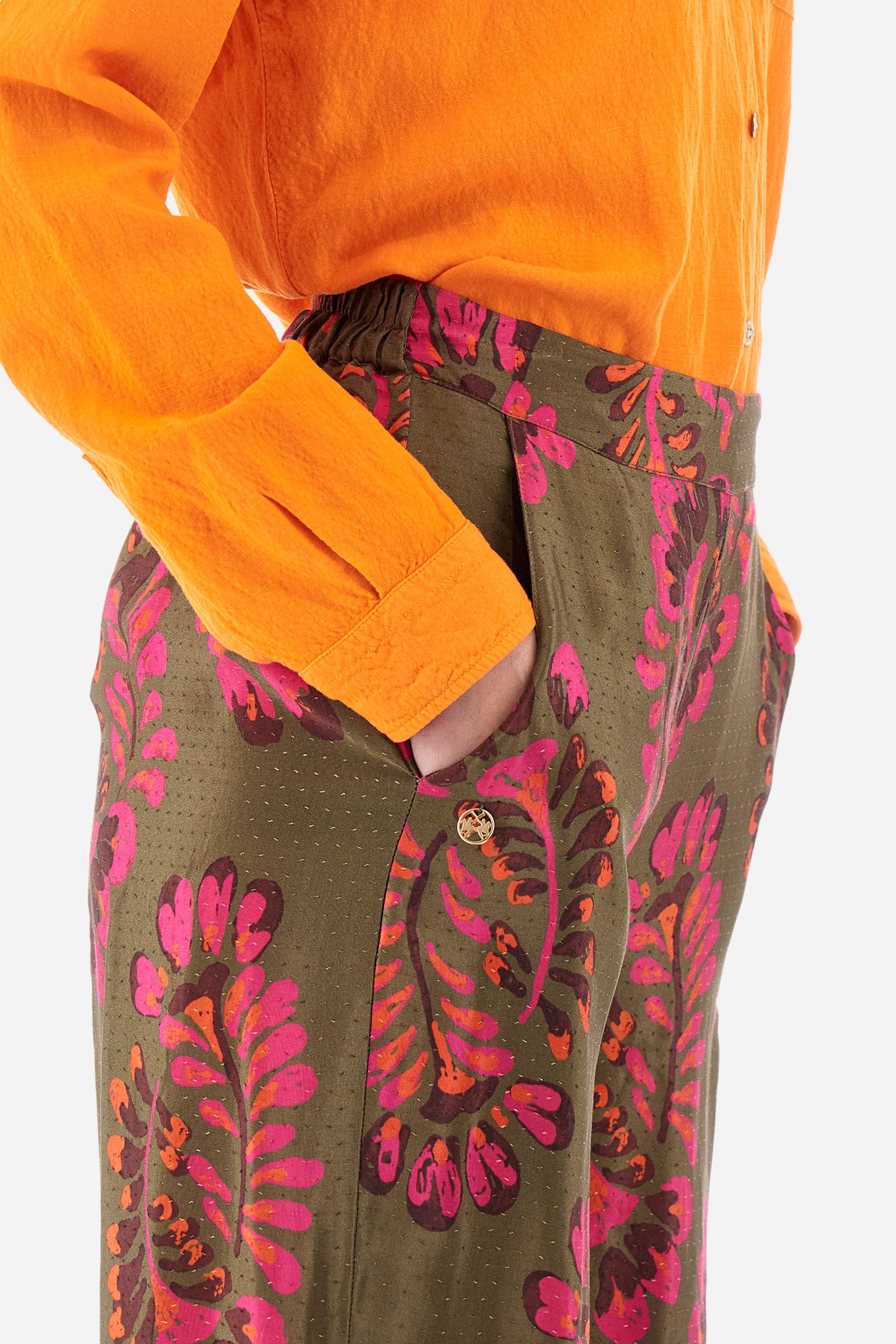 Palazzo trousers for women made of satin viscose fabric. The rich floral stamps and brilliant details on the bottom, in contrasting tones, recall the Argentina capsule collection. Elasticated waistband. Two front welt pockets. Metal label with La Martina logo sewn on the front. The fit is regular. The model wears a size 2. - Military/Hotpink/Fre