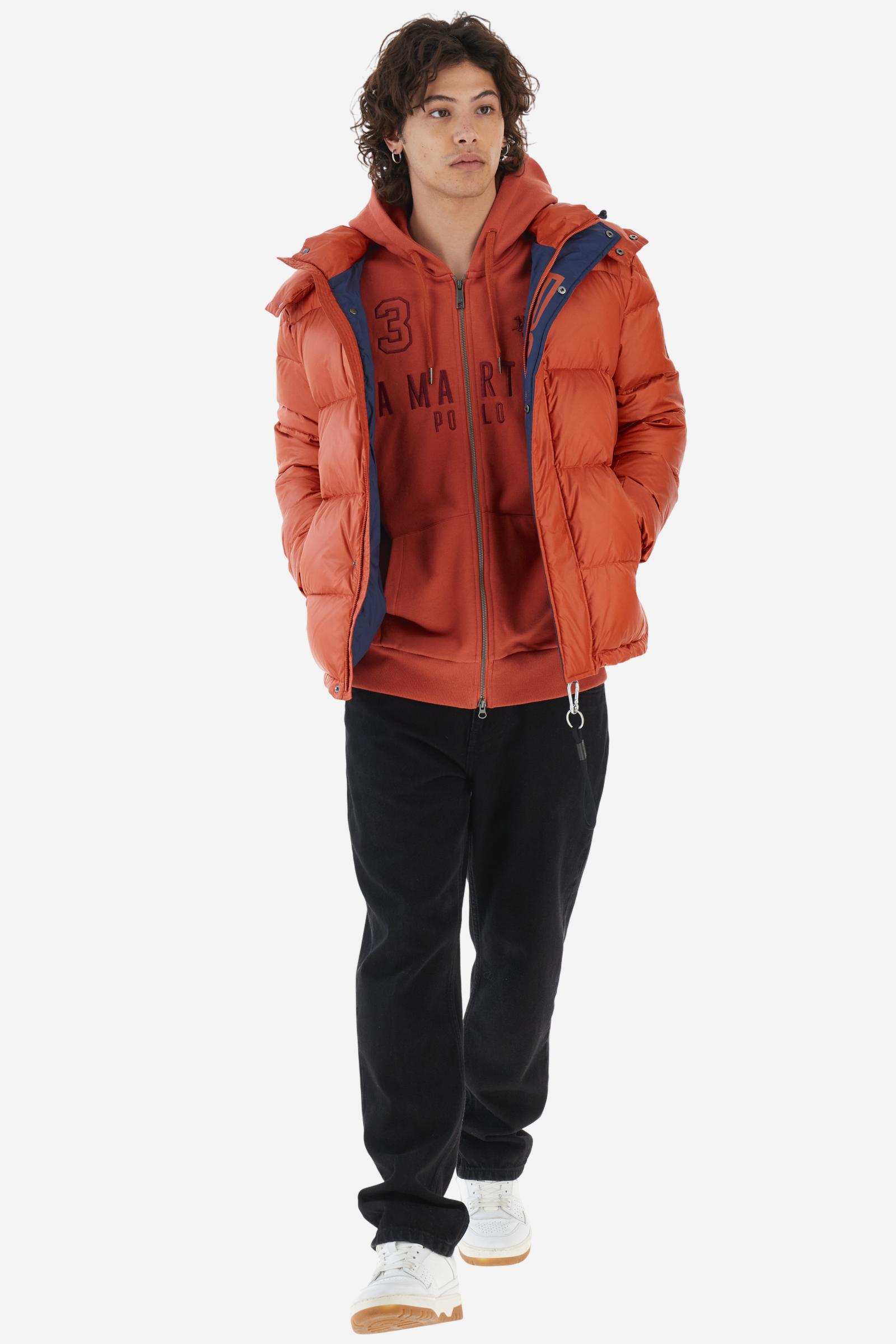 Men's long-sleeved hoodie in solid colour, made from soft 100% cotton fleece with a velvety touch. The model features a customised front zip and an adjustable hood with drawstring. Hem and cuffs in tone-on-tone rib. Iconic brand graphics stand out on the chest, embroidered with numbers and lettering. Regular fit ensuring comfort and freedom of movement. Model wears size L. - Burnt Ochre