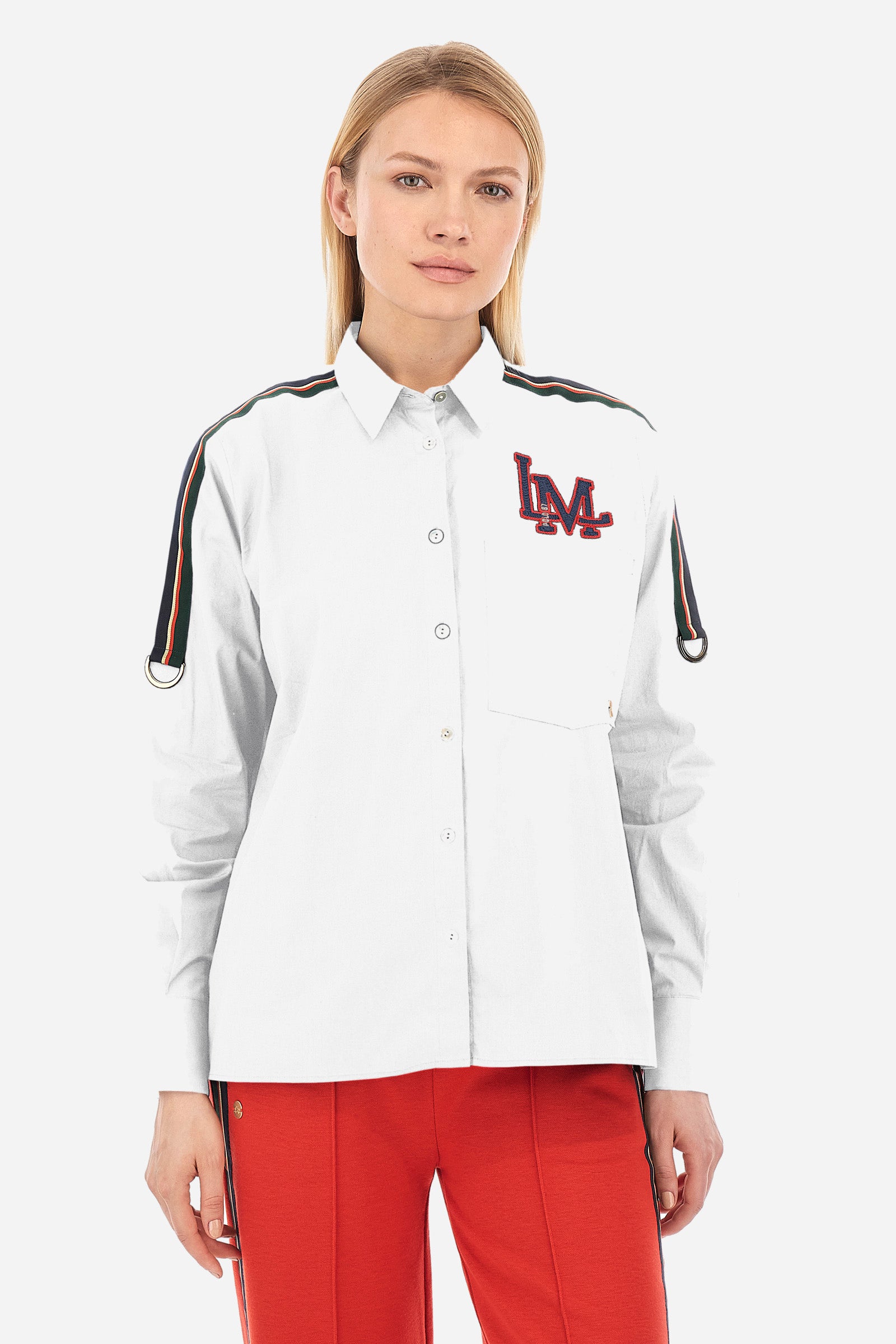 Solid-coloured long-sleeved women's shirt, made of stretch cotton with a regular fit. The line is Polo Academy and features a classic collar with button fastening. The chest is embellished with the LM patch and on the shoulders there is a contrasting band applied with a final ring. Finally, the shirt has a front pocket for added practicality. The model is 174 cm tall and wears a size 2. - Optic White