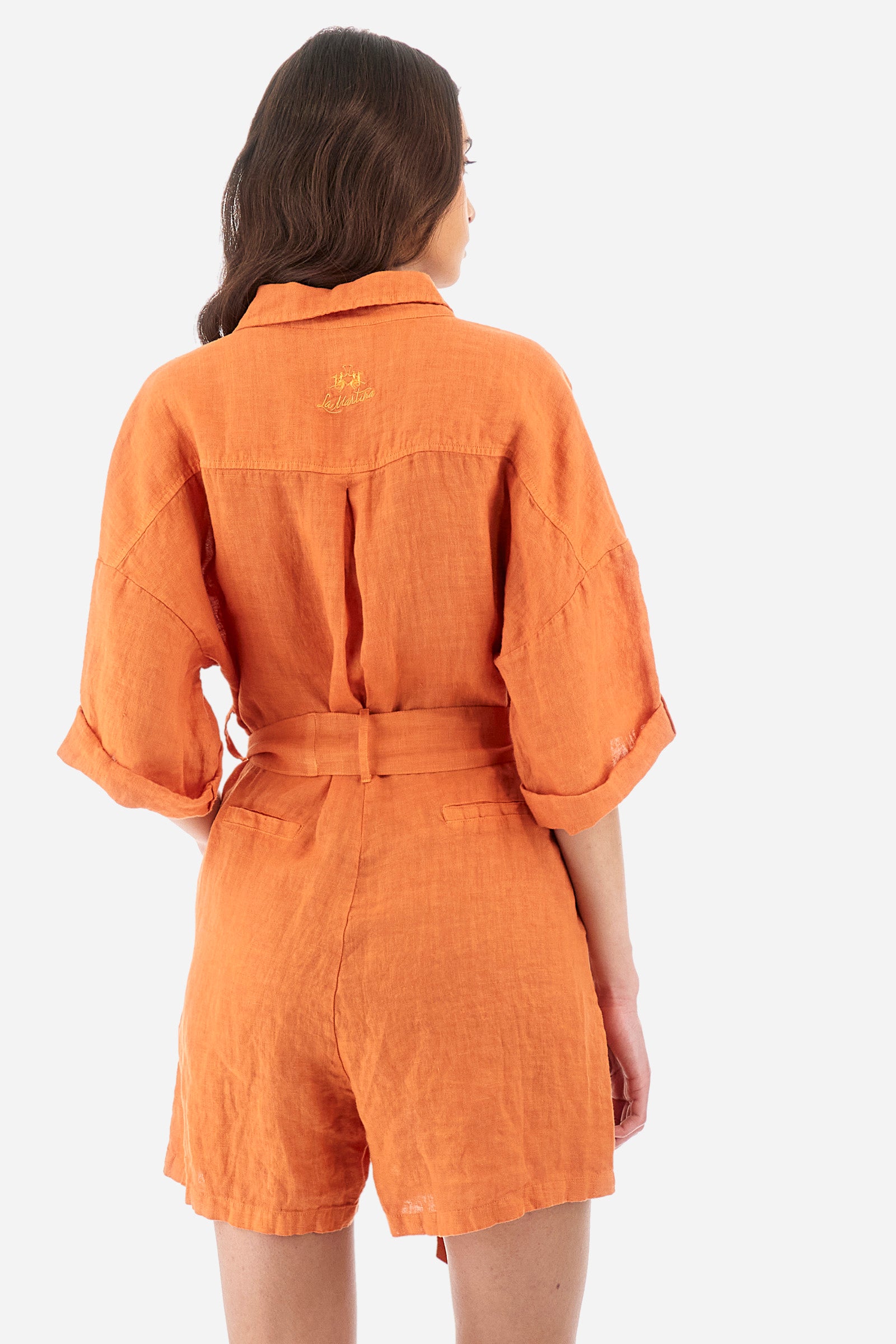 Women's one-piece playsuit with 3/4 sleeves with cuff and single-colour shorts. In 100% linen. French collar. With button fastening. Belt loops and fabric belt included. Featuring two front welt pockets and two back pockets. A logo and the lettering "La Martina" are embroidered on the back. The fit is regular. The model wears a size IT40. - Celosia Orange