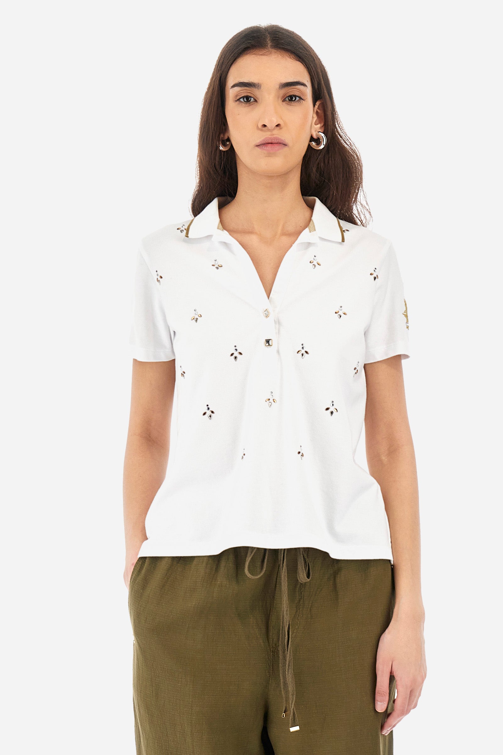 Women’s polo with short sleeves in solid color from the Guards line. Made of stretch cotton. V-neck and 2-button jewel closure. Ribbed collar. Side slits. Rhinestones of various shapes, sizes and colors were applied to the front. The logo and the characteristic symbol of the line are embroidered on a sleeve. The fit is regular. The model wears a size 2 . - Optic White
