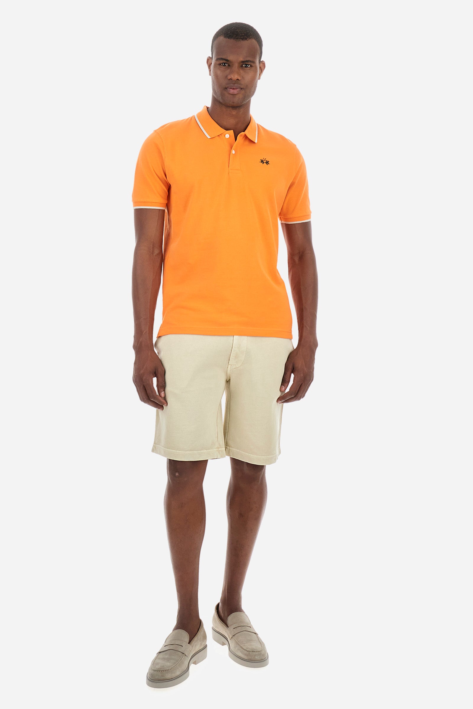 Men’s polo with short sleeves in stretch pique cotton. A classic La Martina, with a simple and linear style. The regular fit fits easily to any type of silhouette. A small La Martina logo is embroidered on the chest, in contrasting shades like the sleeve edge. The model is 187 cm tall and wears a size L. - Celosia Orange
