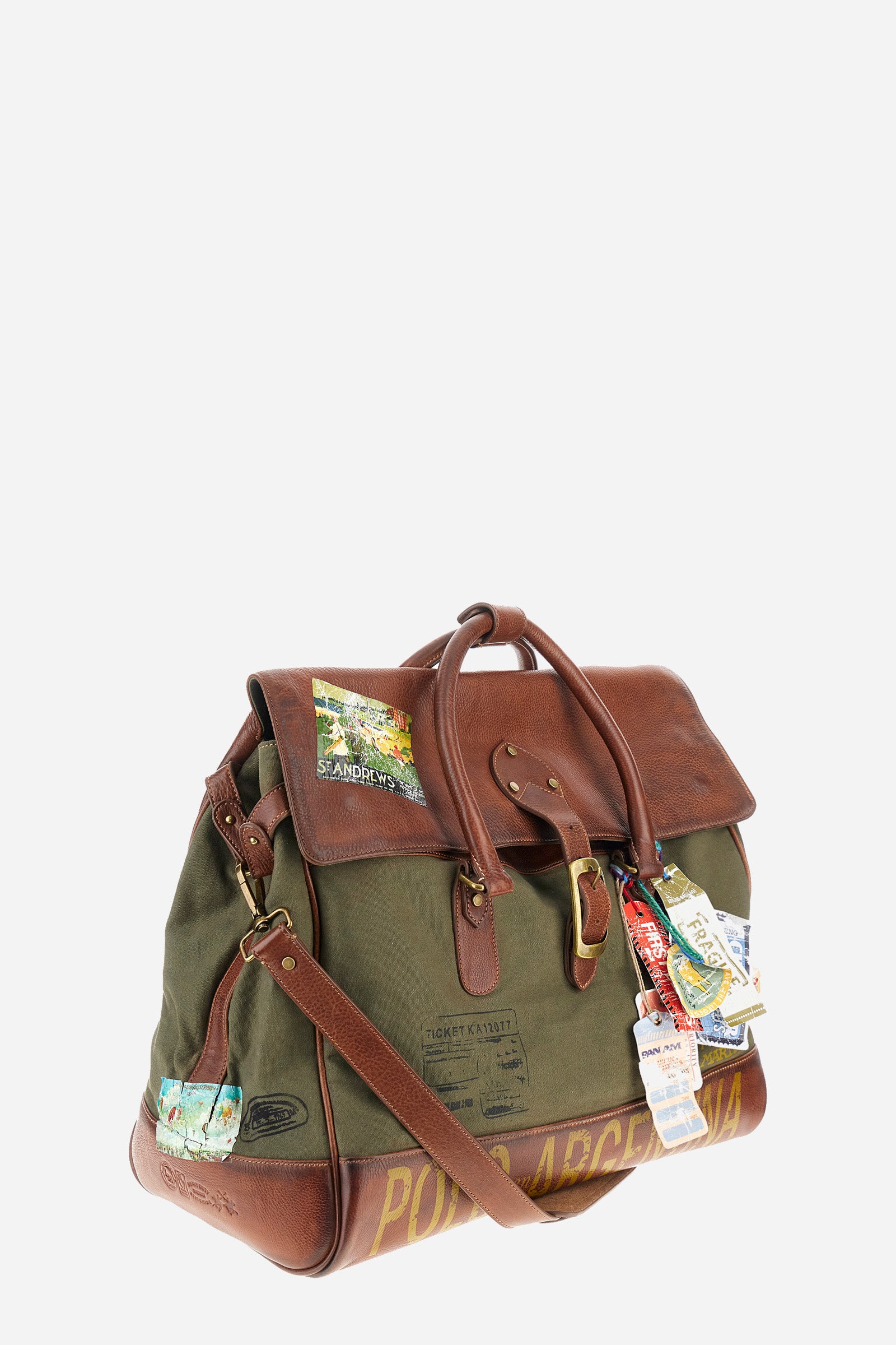 Unisex bicolor duffel bag made of 100% leather. Snap button closure. Equipped with two handles and a removable shoulder strap. Inside, there is a zippered pocket. Iconic design of the brand, embellished with writings, patches, and applied labels throughout the accessory. The La Martina logo is on the back. Dimensions (width x height x depth) 68x43x26 cm. - Military Olive