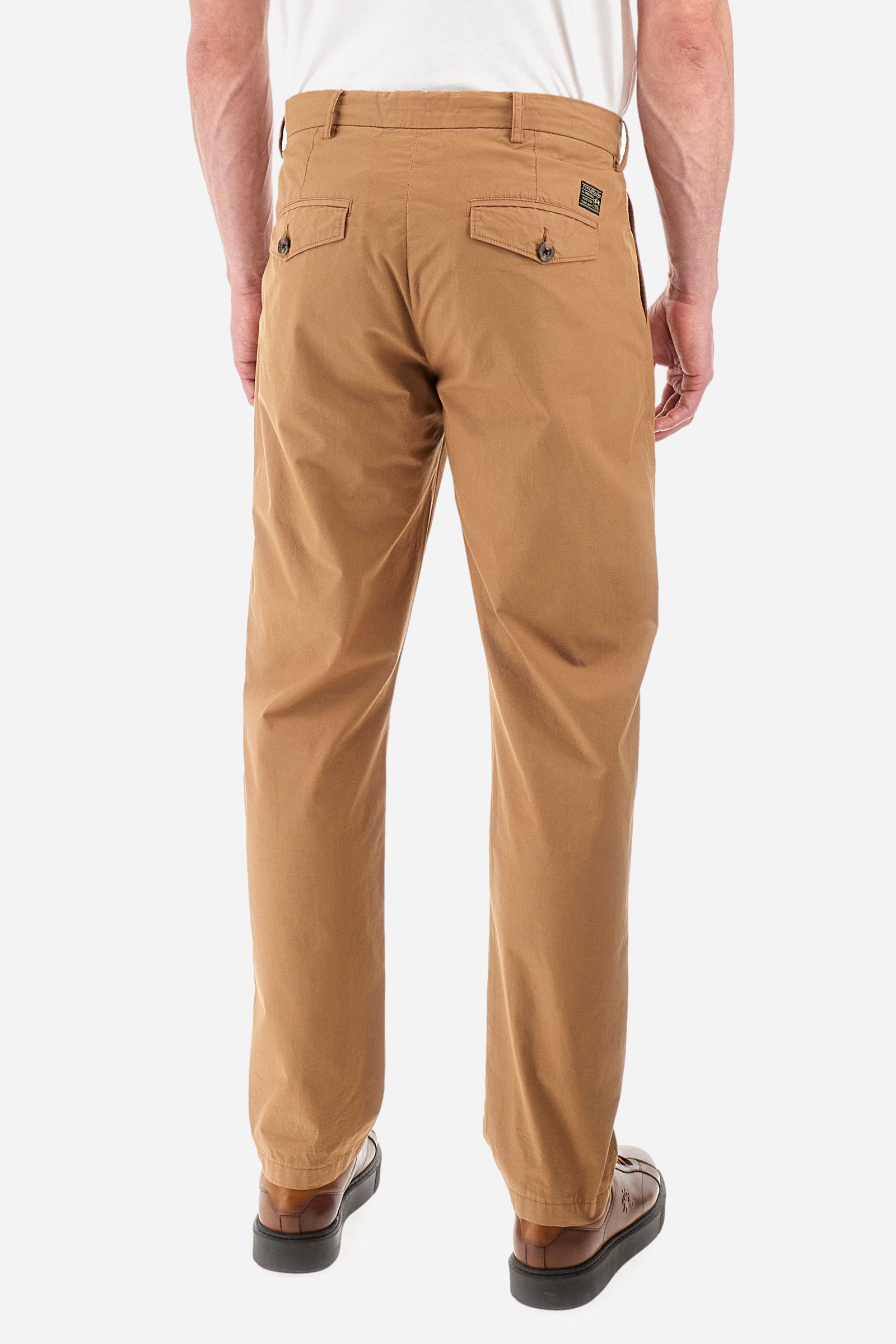 Men's single-colour chinos in 100% cotton. With belt loops, zip and button fastening. Darts on the front. There are two open front pockets and two closed back pockets with a classic button fastening. There is a logo with a patch sewn onto the reverse. The fit is regular. The model wears a size 33. - Tobacco Brown