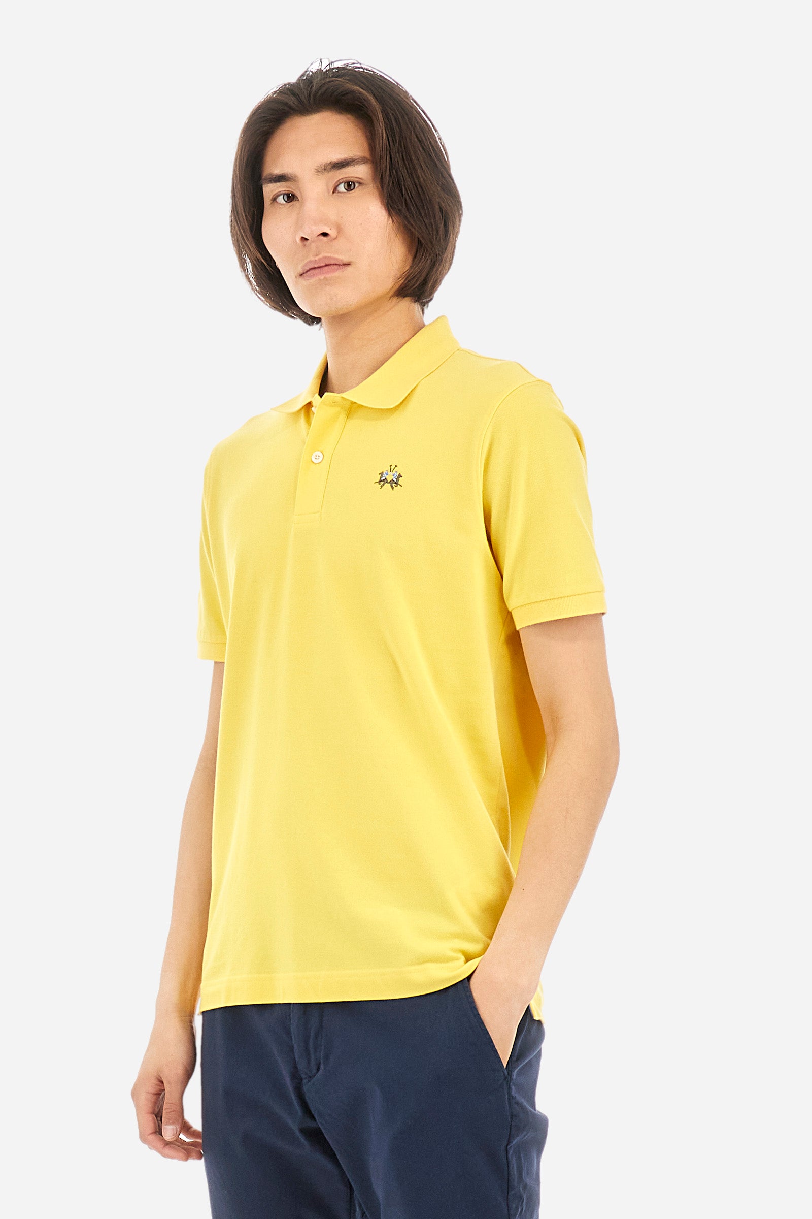 Men's single-colour short-sleeved polo in elasticated cotton. Two-button fastening. Tone-on-tone stitching. Ribbed collar and armholes. The "La Martina" lettering can be found under the collar. Featuring a small logo embroidered on the chest. In a slim fit. The model wears a size L. - Aspen Gold