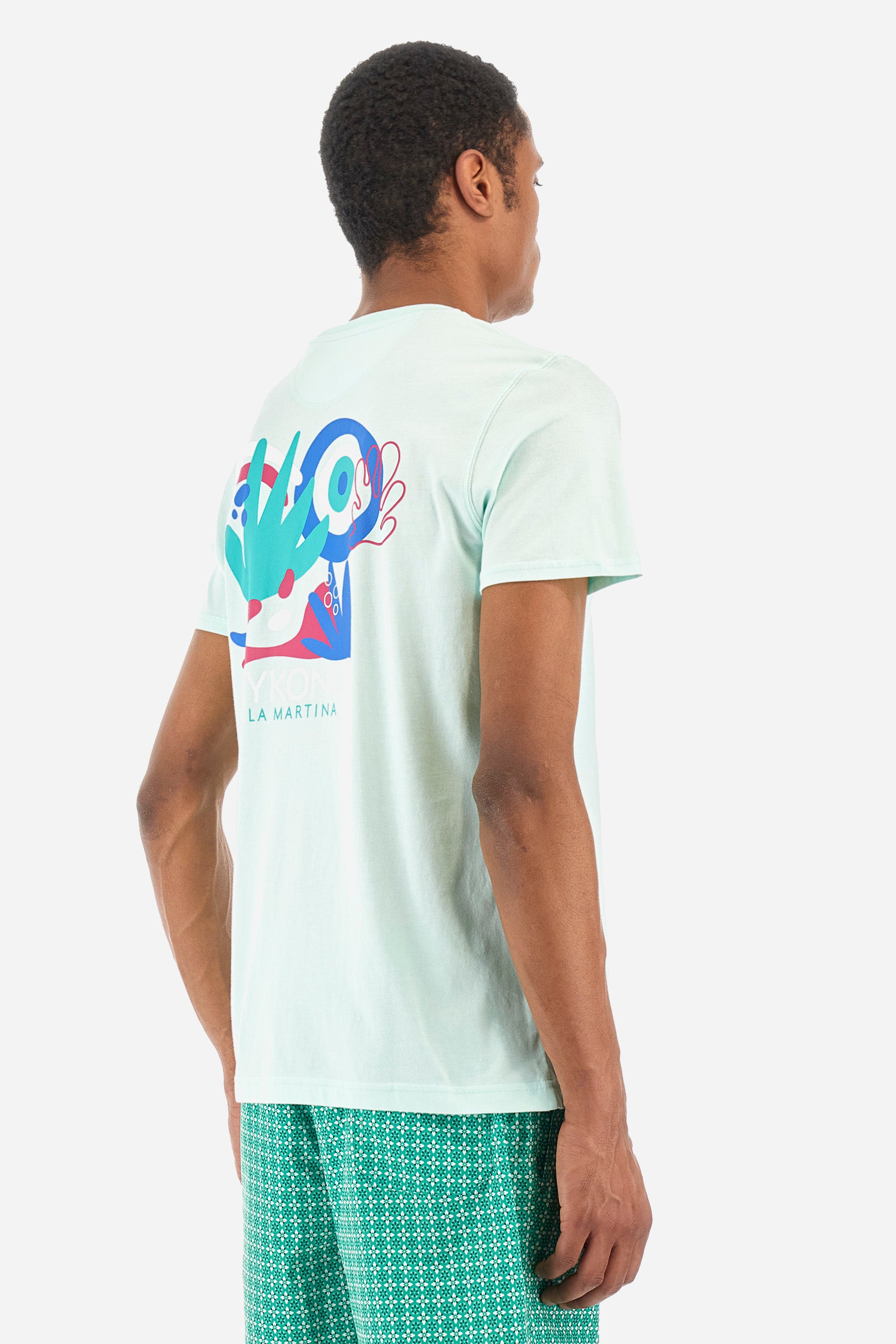 Men's short-sleeved T-shirt with a crew neck in a single colour. Made of 100% cotton. Printed on the front are the words "Mykonos" and "La Martina". On the back we find stylised prints inspired by Greece and the lettering that is also present on the front. Regular fit. The model wears a size L. - Honeydew