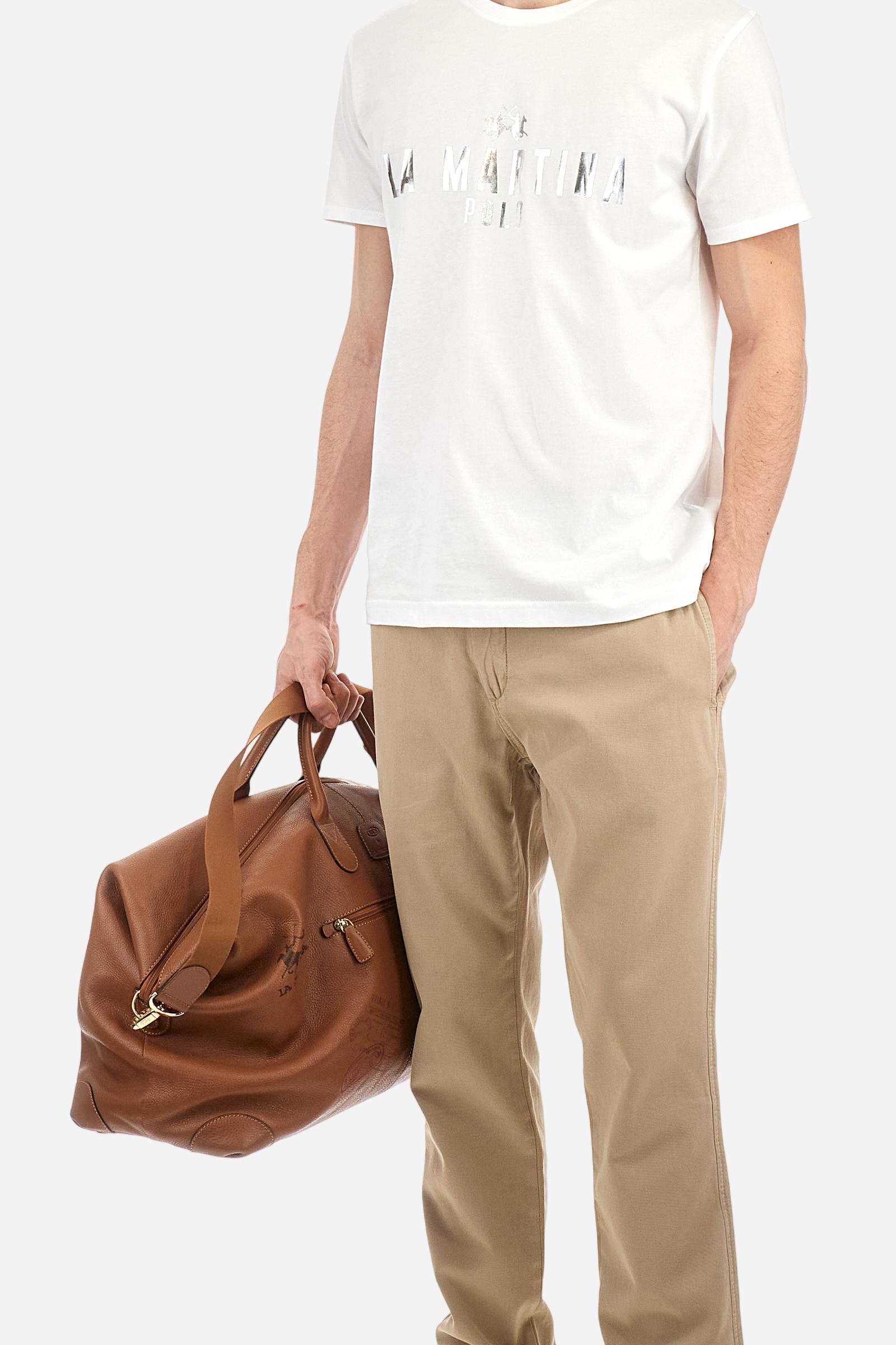 Single-colour men's chino trousers made of cotton and linen canvas. Straight leg. Zip fastening and faux horn button. The side pockets are inserted in the side and on the front, at the right, under the strap, there is a small coin pocket. The back pockets are double-welted and fasten with a visible faux horn button. The logo is present on a fabric patch sewn on the back. Regular fit. The model is wearing a size 33. - Twill