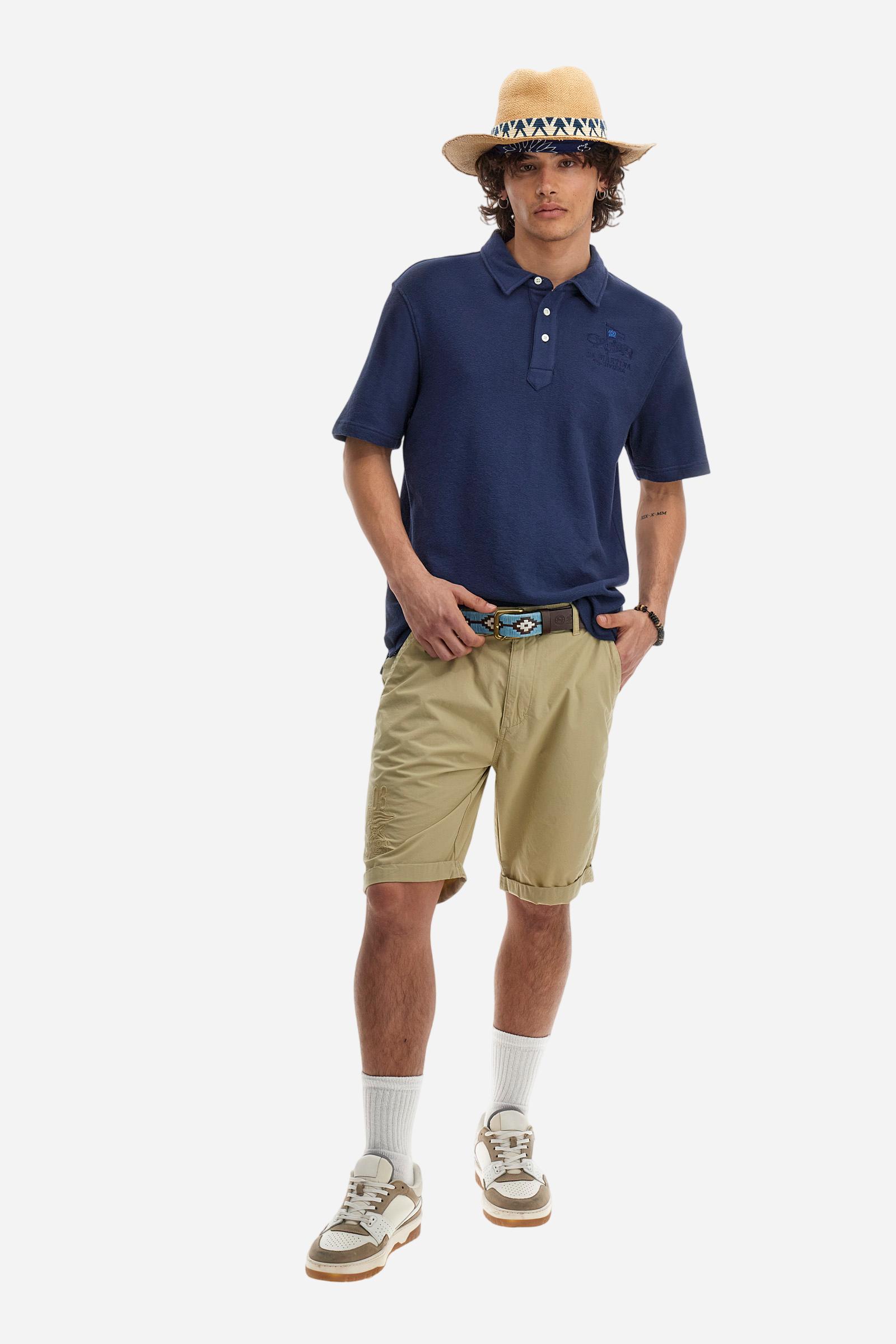 Men's plain short-sleeved polo shirt made from brushed jersey. Three-button fastening. The embroidery on the left side of the chest, in contrasting thread, is inspired by the French Riviera. A small logo is embroidered on the left sleeve, also using contrasting thread. Regular fit. The model is wearing a size L. - Navy