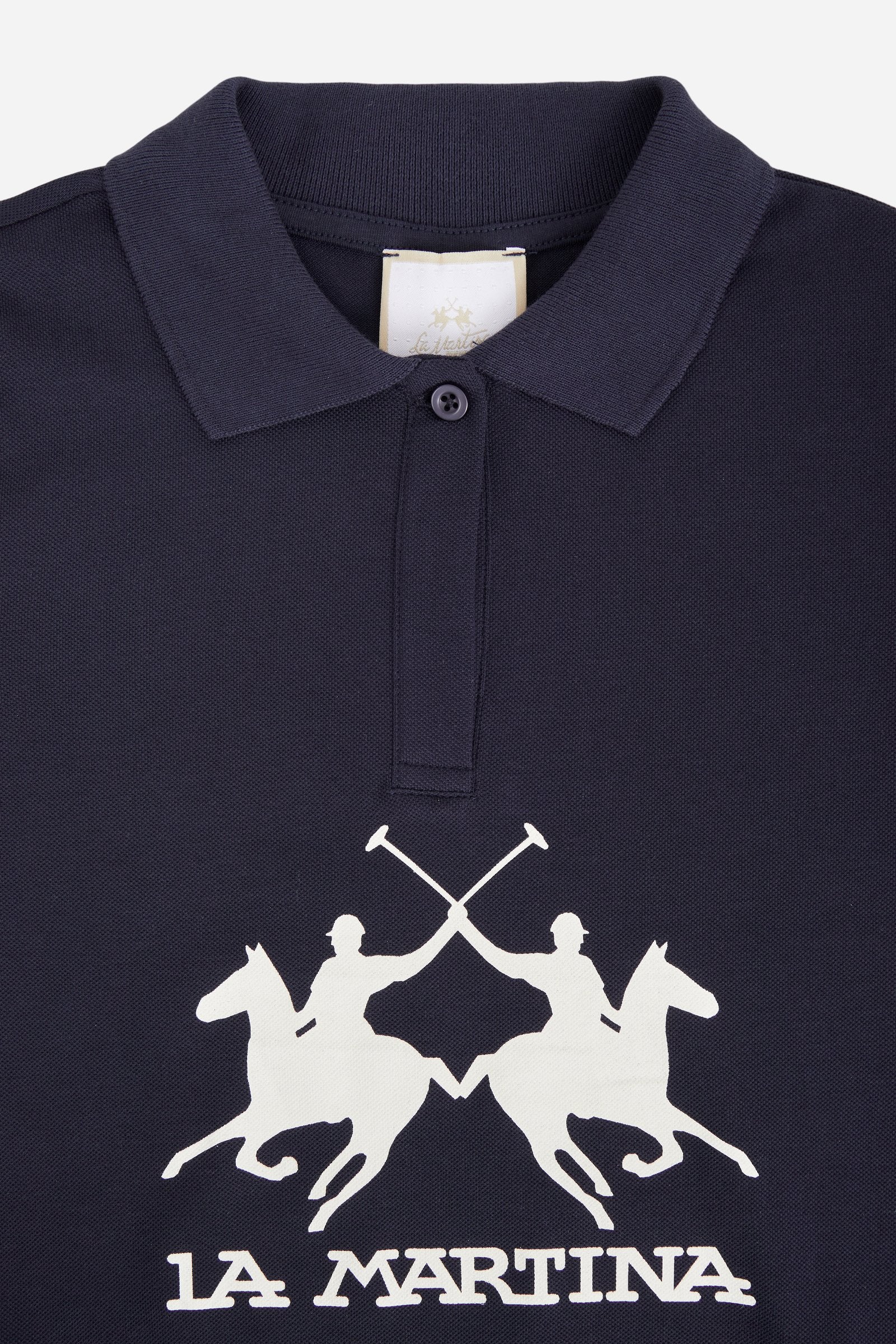 Short-sleeved polo shirt for girls made from soft 100% cotton piqué in a solid colour. The style features a regular fit, hip length and shirt collar in the same fabric with a buttonless V-neck. The contrast maxi front print, featuring the brand logo, gives the garment strong visual impact and a sporty, feminine style. - Navy