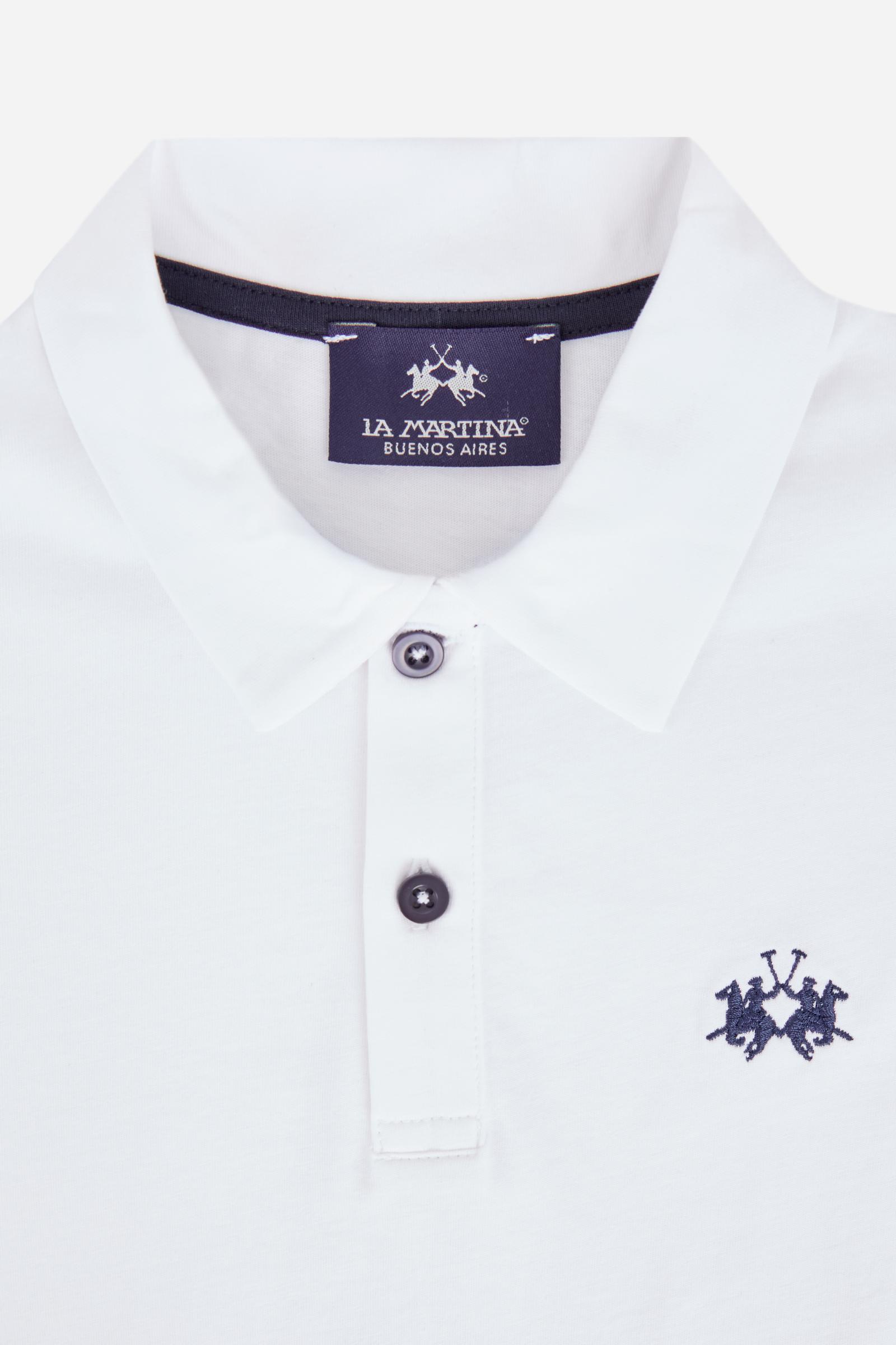 Short-sleeved polo shirt for boys made from 100% cotton jersey in a solid colour. The style features a regular fit, two-button front opening and shirt collar in the same fabric. The contrast inner collar tape recalls the small brand logo embroidered on the chest, adding a distinctive detail to an essential and versatile garment. - Optic White