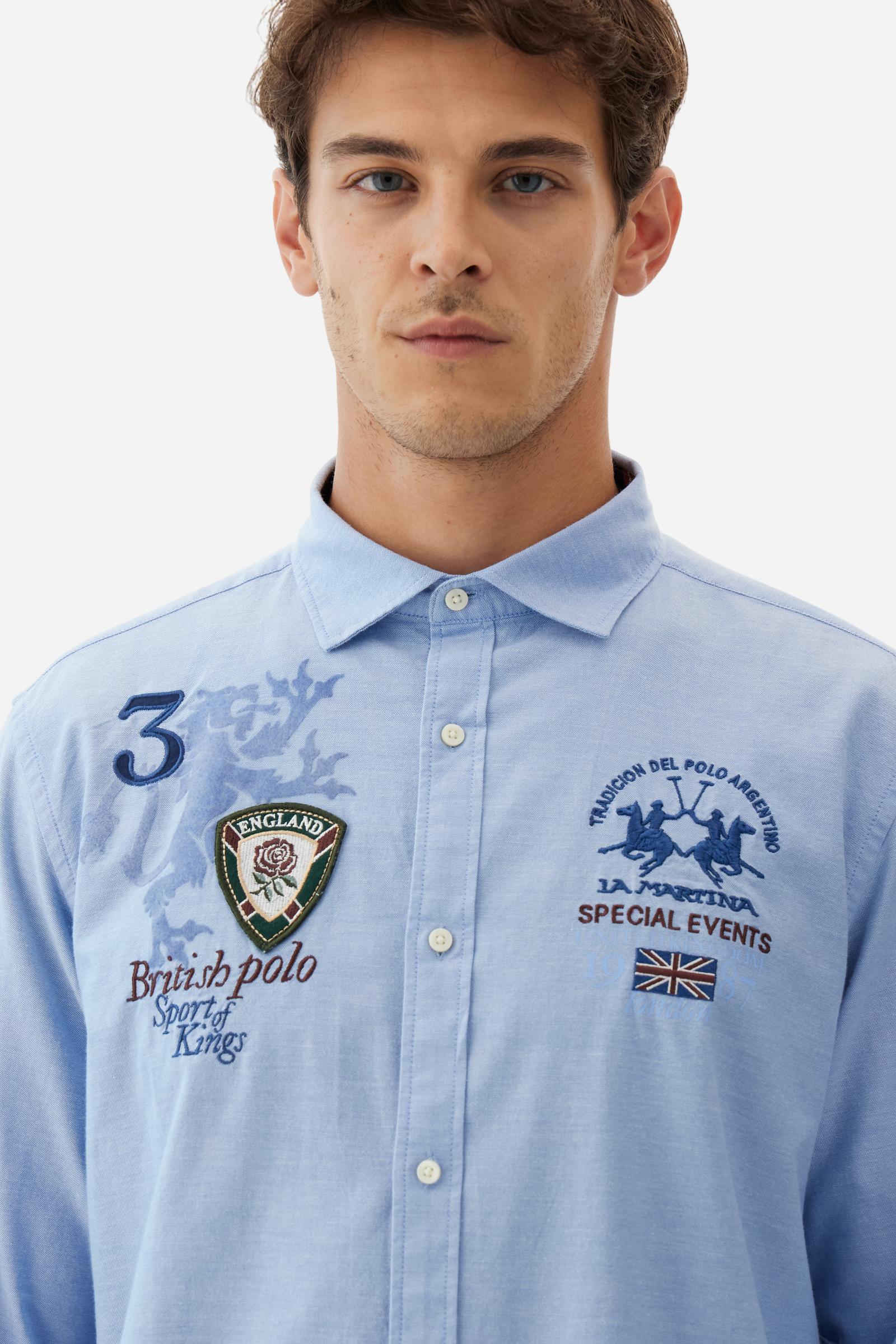 Classic men's long-sleeved shirt in stretch cotton Oxford, solid colour. Finished with a French collar and interior regimental-pattern fabric details. Chest features multicolour prints and embroideries inspired by British Polo, including the large team logo embroidered in contrast. Regular fit ensuring comfort and enhancing any physique. Model wears size L. - Cornflower blue
