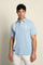 Men’s heavy cotton jersey polo with three-button placket and striped details. Celebratory maxi graphic and bold lettering. - Blue Bell