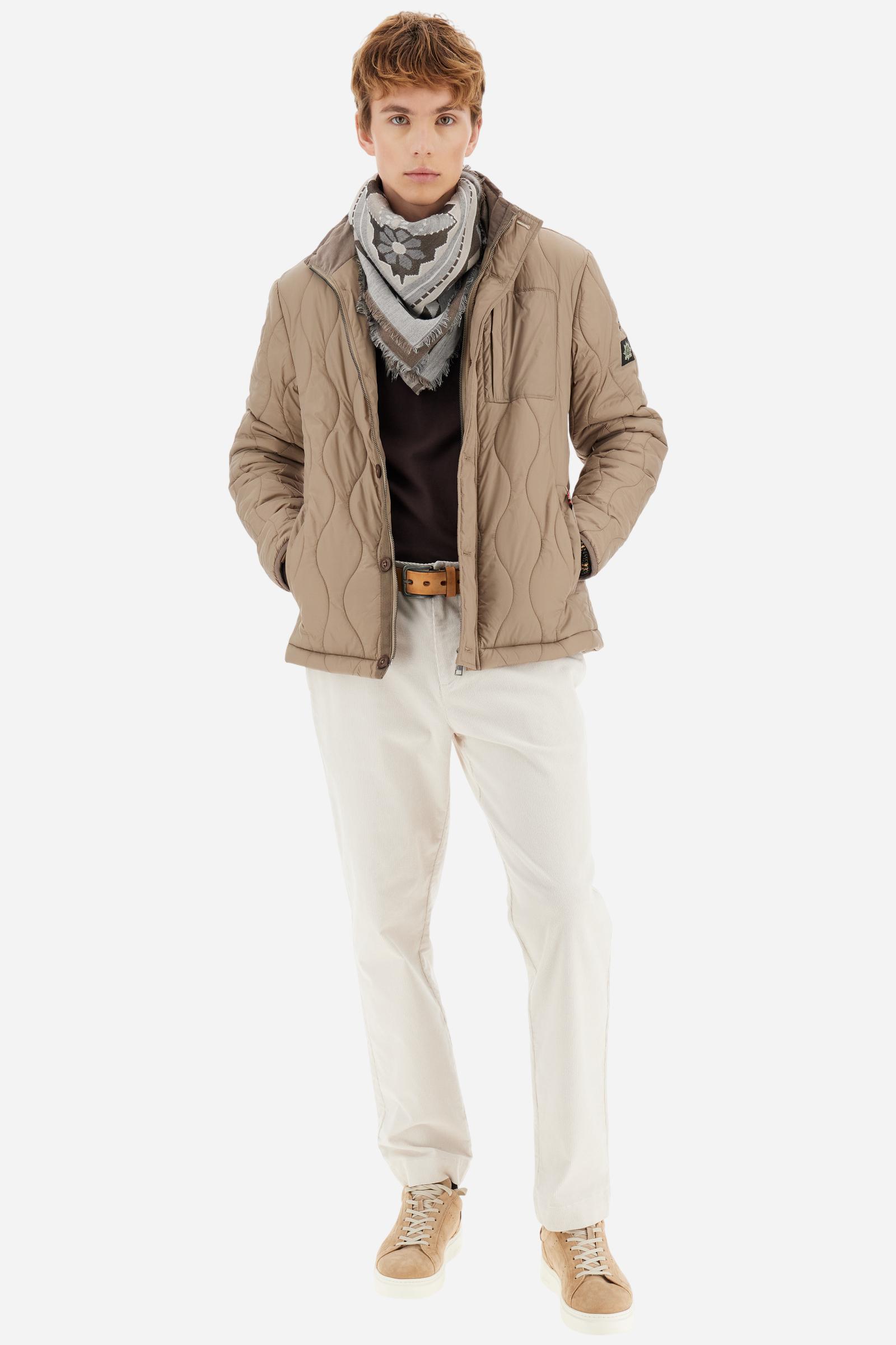 Men’s long chino trousers made of stretch cotton corduroy. Featuring practical slant pockets at the sides and welt pockets at the back, which add a sartorial touch to this basic design. The logo appears on the institutional brand label applied above the back pocket. The regular fit offers a classic silhouette, not too wide and not too slim, perfect for work or casual occasions. Model wears size 33. - Sand Shell