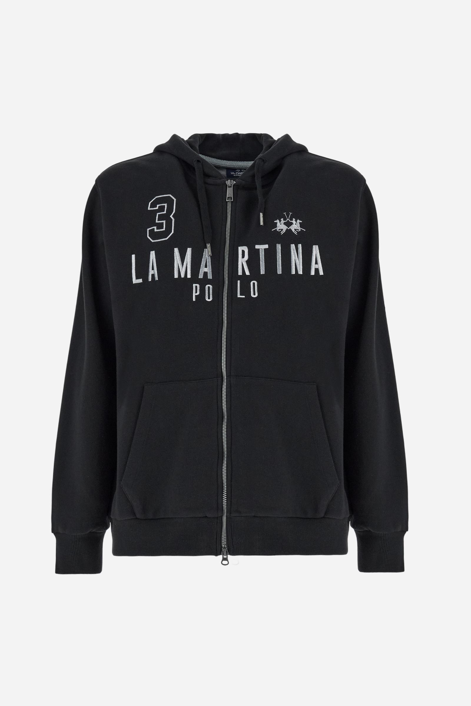 Men's long-sleeved hoodie in solid colour, made from soft 100% cotton fleece with a velvety touch. The model features a customised front zip and an adjustable hood with drawstring. Hem and cuffs in tone-on-tone rib. Iconic brand graphics stand out on the chest, embroidered with numbers and lettering. Regular fit ensuring comfort and freedom of movement. Model wears size L. - Black