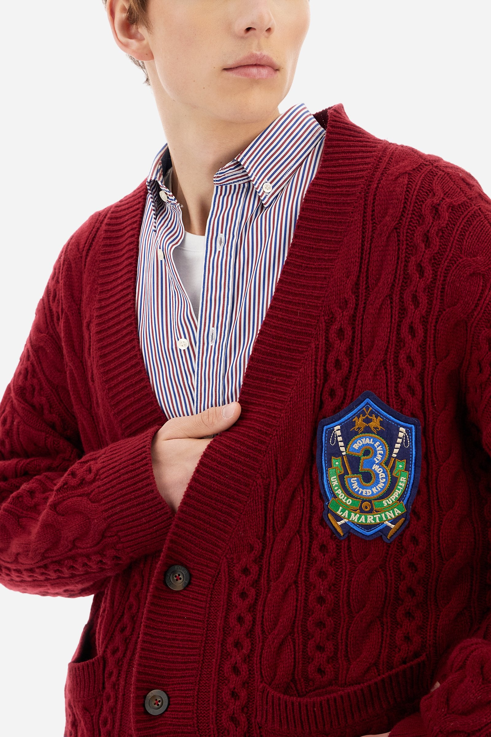 Men’s cardigan with long sleeves in solid-colour lambswool with cable-knit pattern for a refined and classic look. Deep neckline, ribbed cuffs and hem, closure with personalised horn-effect buttons. Applied front pockets and bicolour bands on the hem reflecting the chest patch colours. Oversized fit with dropped shoulders for a modern silhouette. The model wears size L. - Chili Pepper