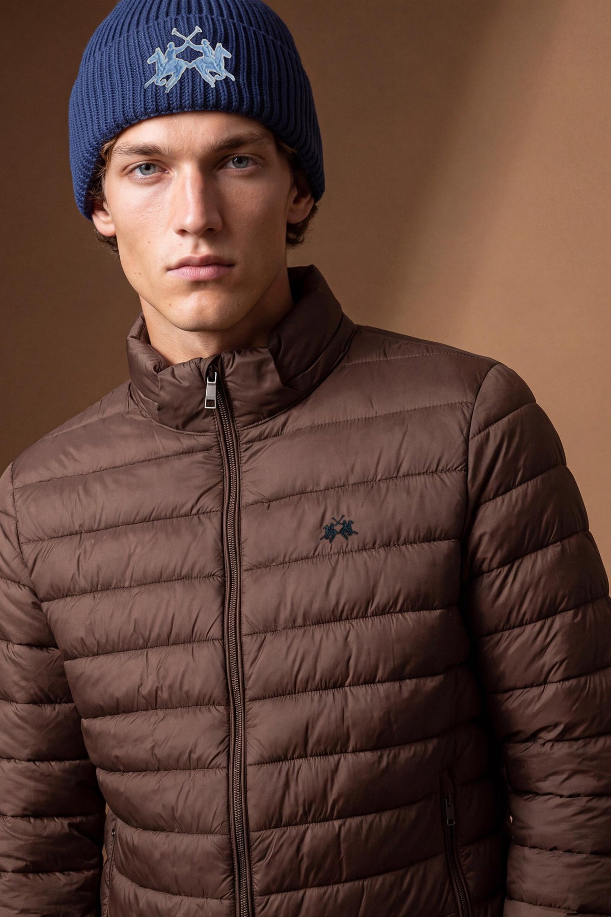 Short men's down jacket with quilted padding for warmth, nylon shell, zippered pockets, elastic cuffs, integrated hood, and a relaxed, comfortable fit. - Hot Fudge