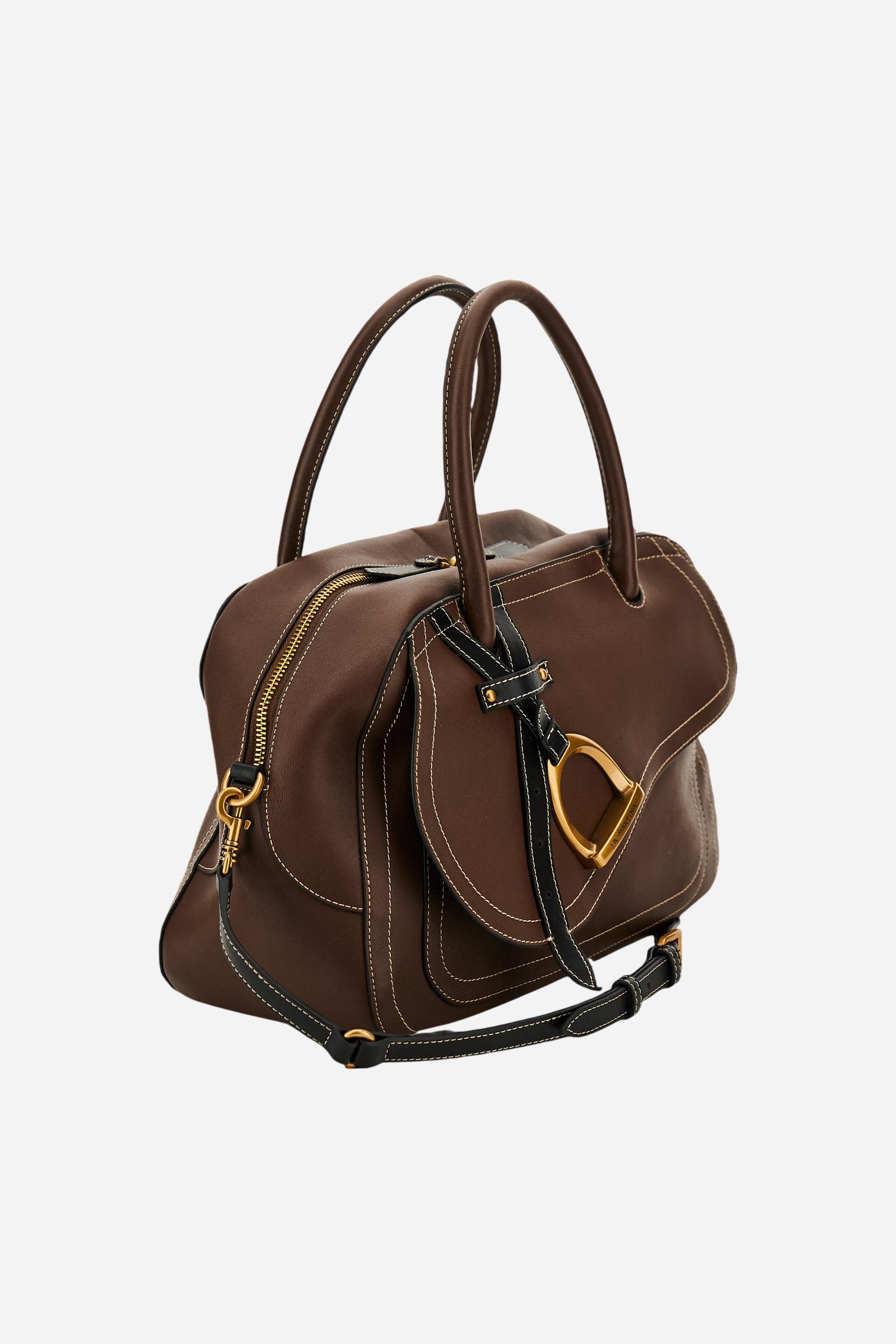 Elegant women's tote in full-grain leather with semi-rigid structure, gold-tone stirrup detail, double handles, adjustable strap, and roomy, secure interior. - Sienna/Black