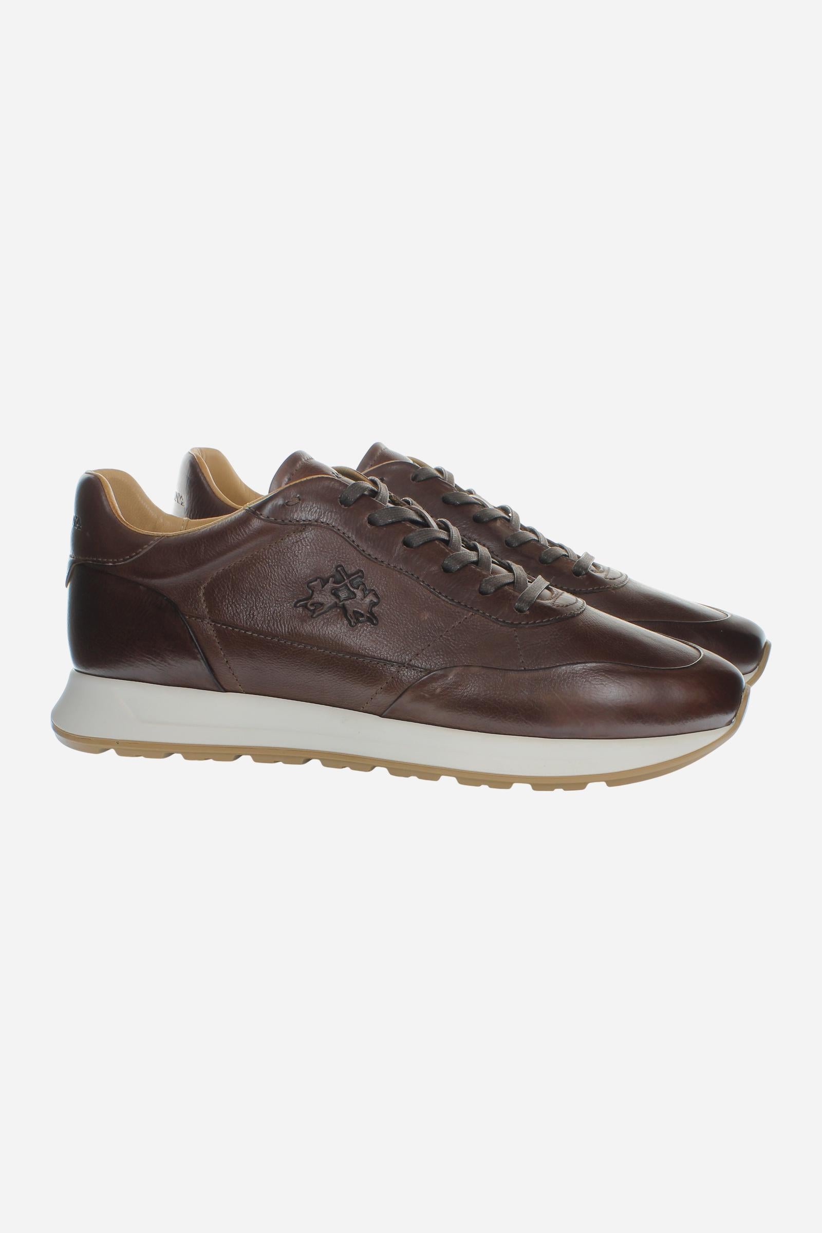 Men's sneaker crafted from soft vegetable-tanned leather with handcrafted stitching, embossed logo, two-tone rubber PU sole, and leather-colored lining. Made in Italy. - Brown