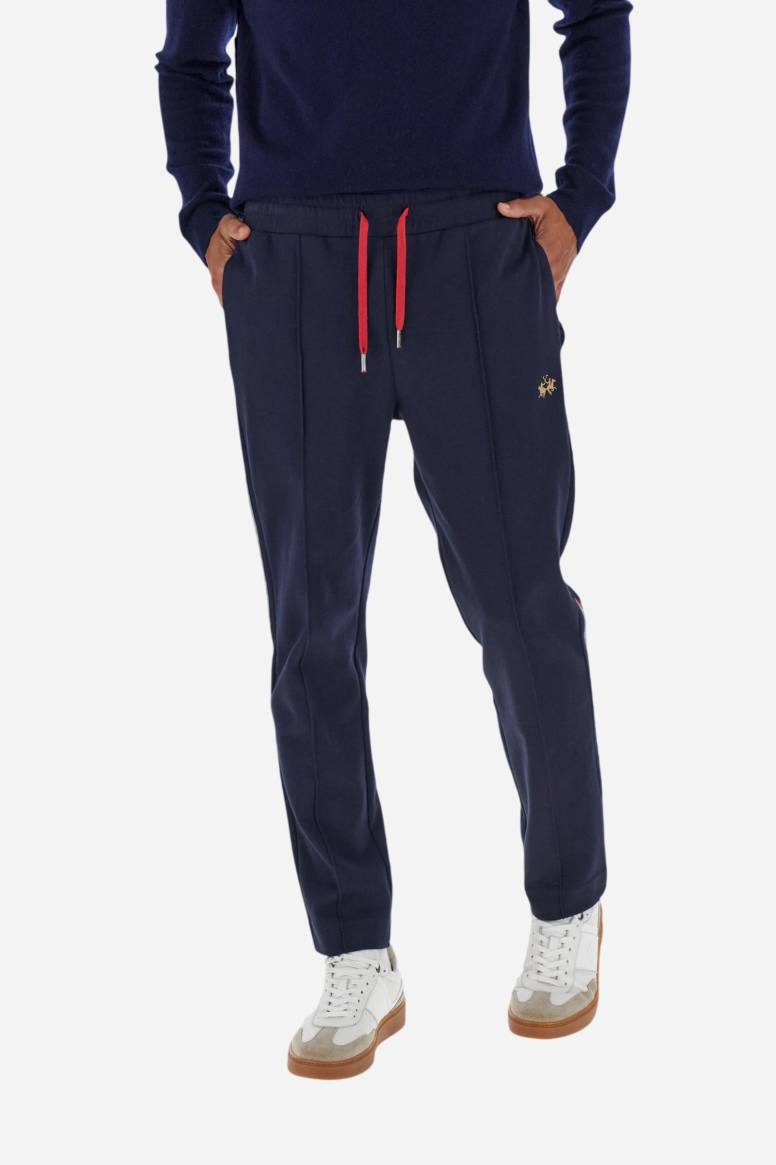 Men’s joggers made of cotton fleece with elastic waistband and contrast drawstring finished with personalized metal tips. Side inset pockets and colorful side bands add a dynamic touch. A central vertical crease on the leg refines the sporty design. Small embroidered logo in contrast under the left pocket. Regular straight-leg fit for a modern, everyday look. Model wears size L. - Navy
