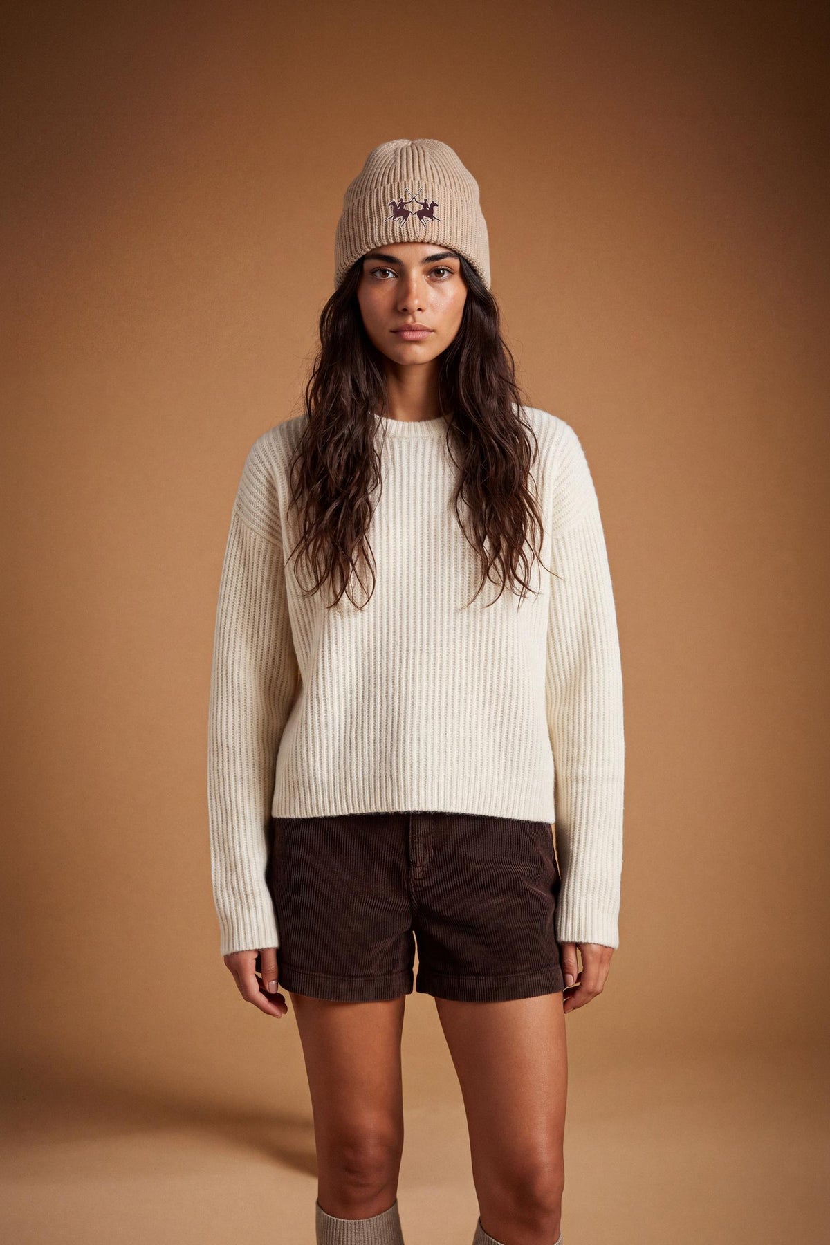 Soft lambswool women's sweater with vertical ribbed knit, relaxed fit, dropped shoulders, cropped length, and a subtle embroidered logo on the back neckline. - Antique White