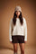 Soft lambswool women's sweater with vertical ribbed knit, relaxed fit, dropped shoulders, cropped length, and a subtle embroidered logo on the back neckline. - Antique White