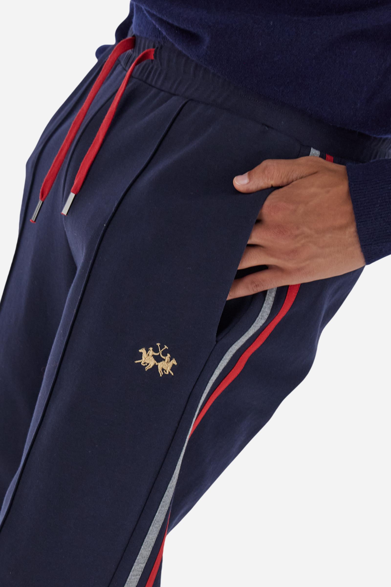 Men’s joggers made of cotton fleece with elastic waistband and contrast drawstring finished with personalized metal tips. Side inset pockets and colorful side bands add a dynamic touch. A central vertical crease on the leg refines the sporty design. Small embroidered logo in contrast under the left pocket. Regular straight-leg fit for a modern, everyday look. Model wears size L. - Navy