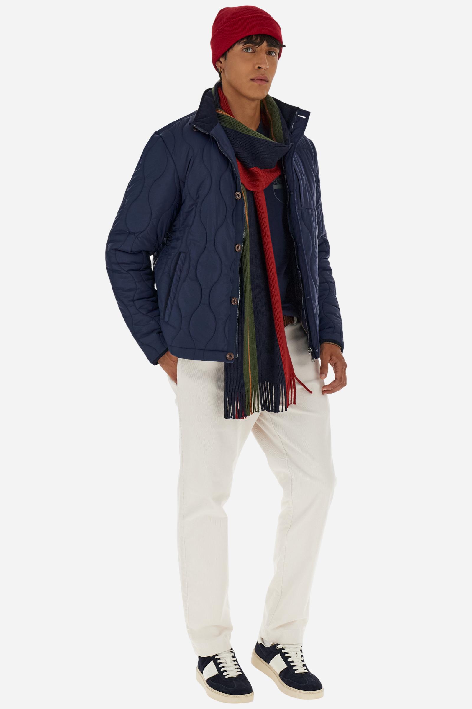 Men’s quilted nylon husky jacket with high collar. Front closure with customized zip and large faux-leather buttons. Interior lined with striped bicolor polyester. Contrast details on the inside (pockets, profiles, back-neck tab). Clean design with chest pocket closed by zip and vertical side pockets. Adjustable back straps with metal snap buttons. Logo patches on the sleeves and multicolor embroidered lettering on the outer collar. Part of the Guards capsule. Regular fit. Model wears size L. - Navy