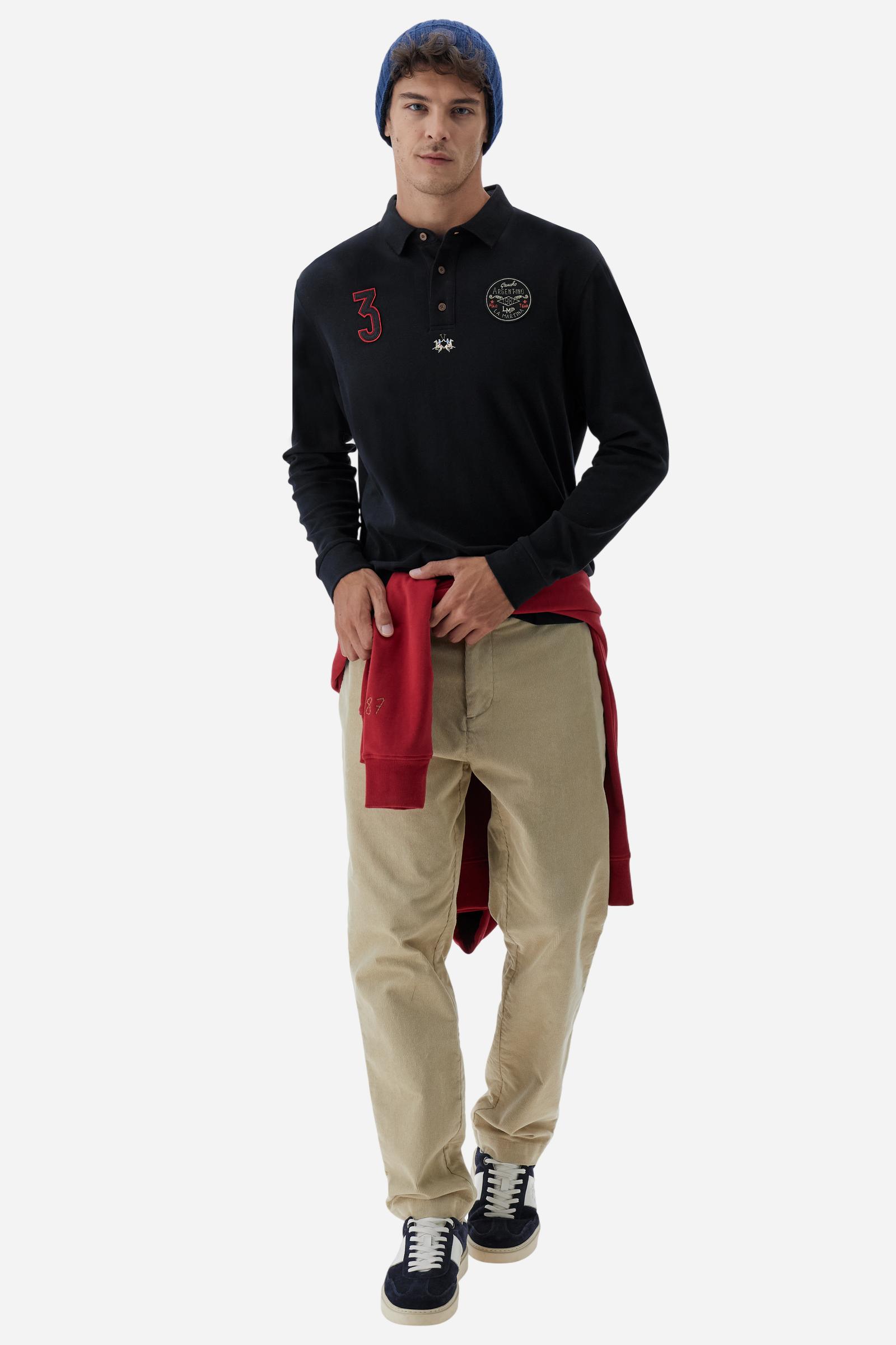 Long-sleeve polo shirt crafted from 100% high-quality cotton jersey. The velvety fabric offers a warm, cozy feel, perfect for cooler seasons. Ribbed collar and cuffs in matching tone, with a three-button personalized placket. A small multicolor embroidered logo sits below the opening, while tonal patches in different shapes and textures, inspired by Argentine culture and Gaucho tradition, decorate the chest and back. Classic regular fit. Model wears size L. - Black