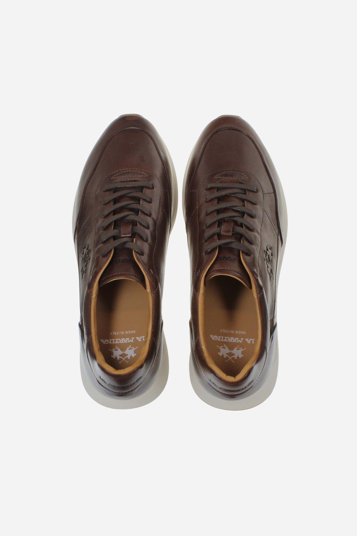 Men's sneaker crafted from soft vegetable-tanned leather with handcrafted stitching, embossed logo, two-tone rubber PU sole, and leather-colored lining. Made in Italy. - Brown