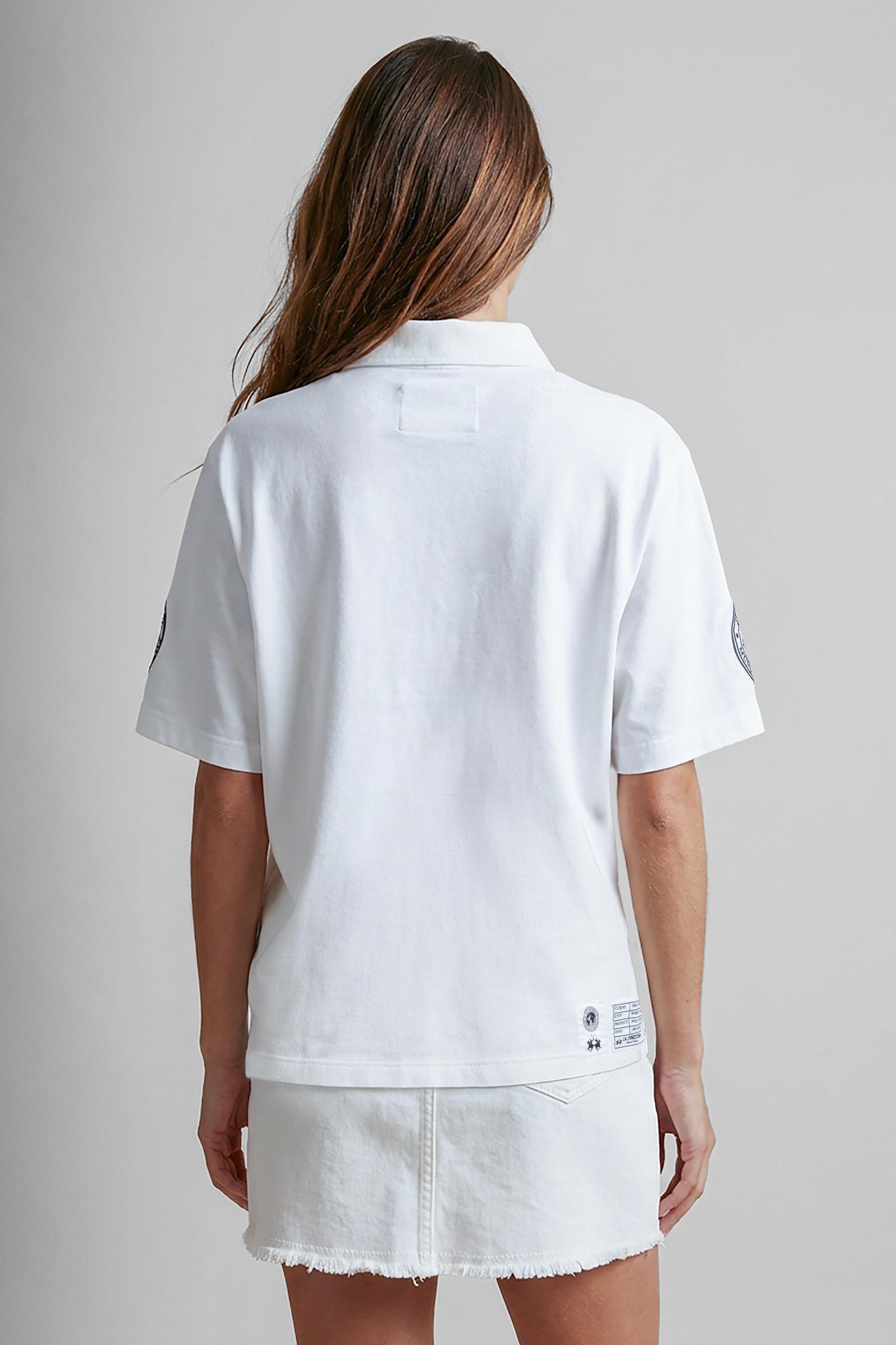 Numbered style with exclusive label, produced in only 100 pieces per style/colour. The label is positioned on the back, at the lower right, with the progressive number clearly visible. Short-sleeved polo shirt made from 100% cotton jersey. The contemporary-cut design features a modern, wide and relaxed silhouette, with a bold and contemporary streetwear attitude. The style is completed with a contrast twill collar and concealed front buttoning. The graphic has a strong visual impact, with lettering and the 