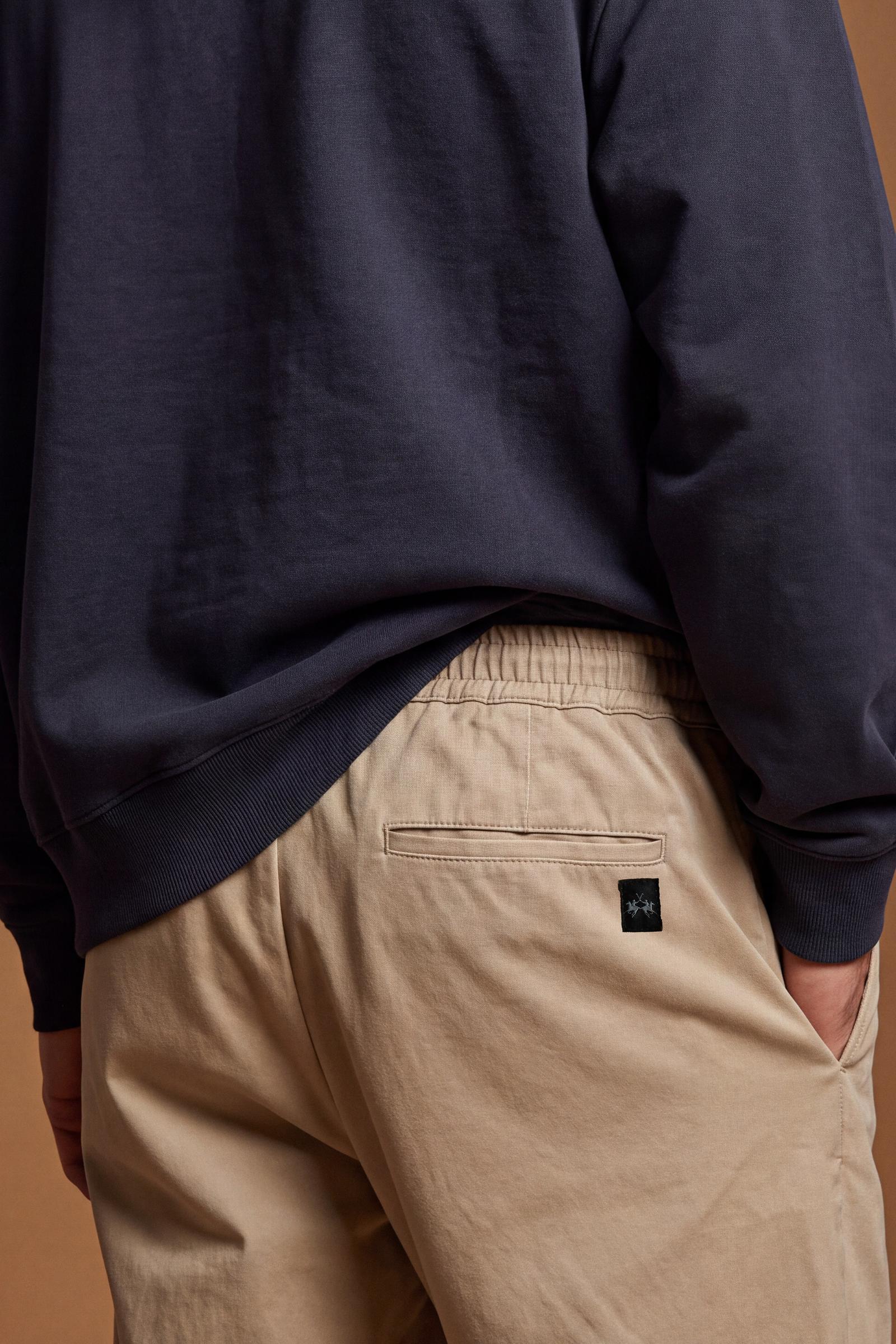 Men's long trousers in stretch cotton twill with elastane for comfort and freedom. Wide thigh, tapered ankle, elastic waistband, drawstring, pleats, and pockets. - Twill