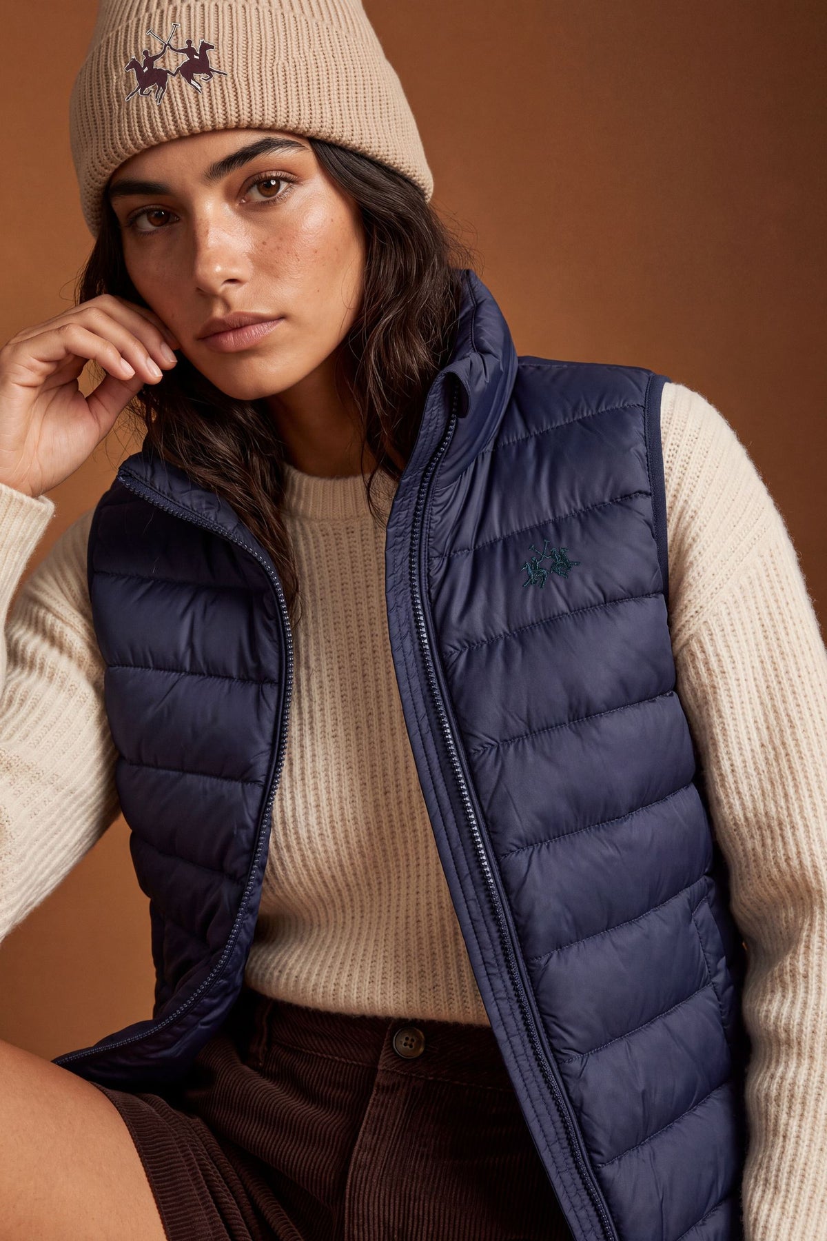 Women's nylon vest with polyamide lining and polyester padding, featuring horizontal quilting, high collar, zip closure, fleece-lined pockets, and adjustable hem for comfort. - Navy Blazer