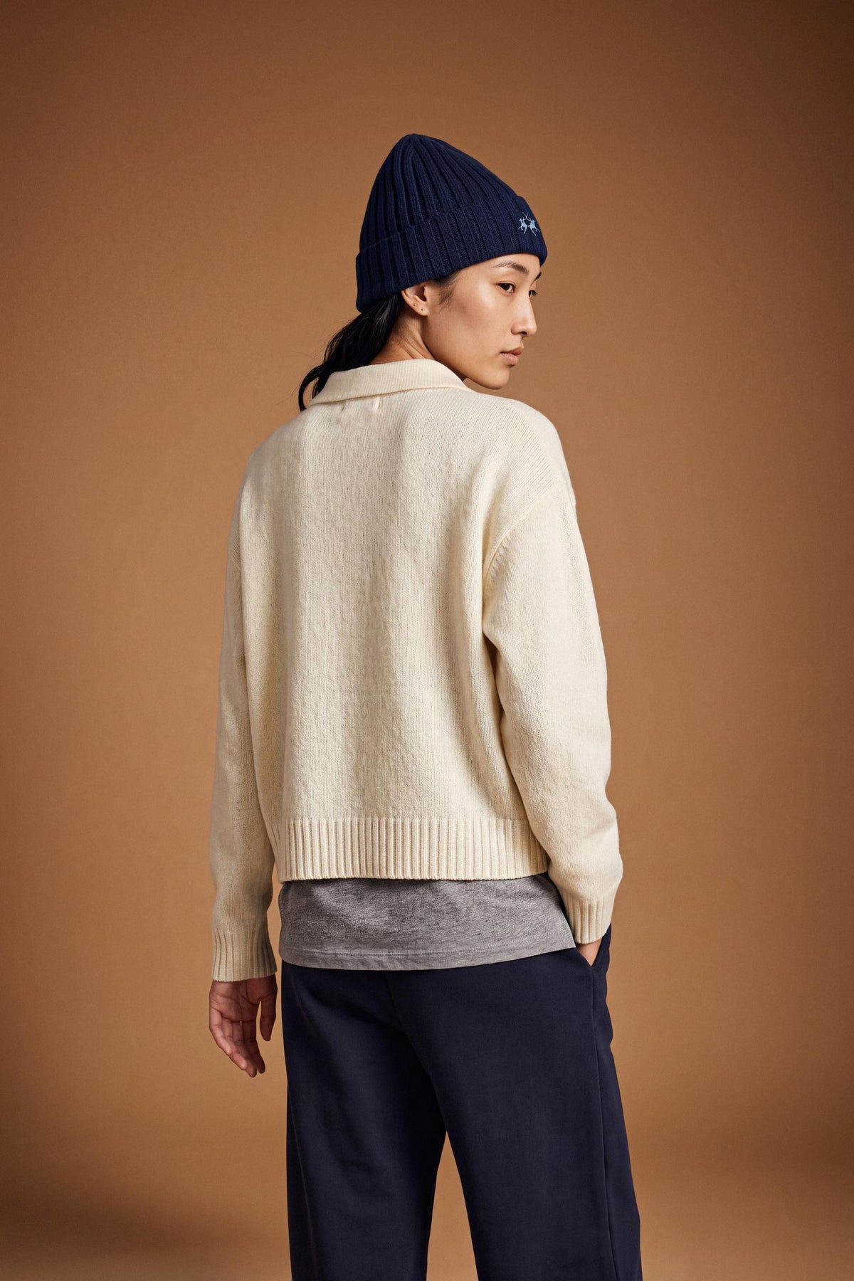 Women's long-sleeve knitted polo in soft lambswool blend, featuring a relaxed cropped fit, ribbed cuffs, shirt-style collar, and smooth, compact knit surface. - Antique White