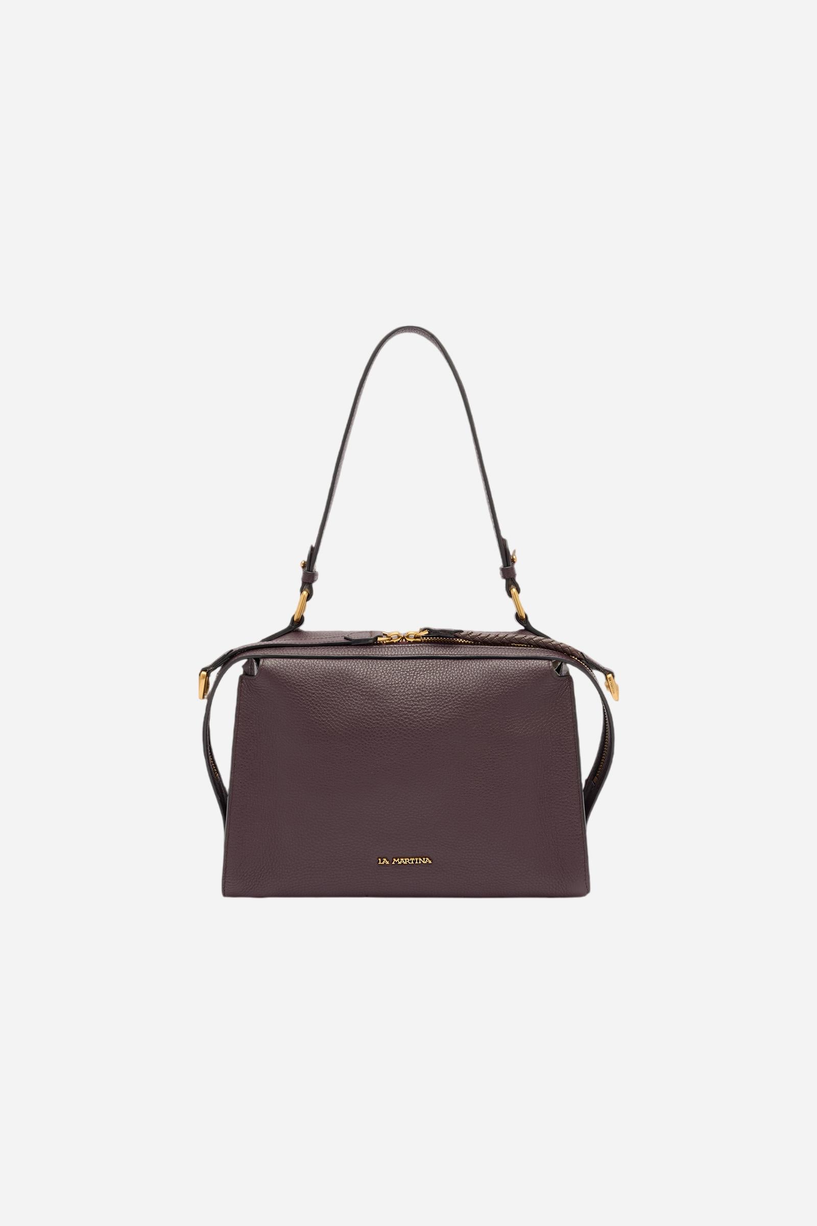 Compact shoulder bag made of high-quality full-grain leather. The double side zip with long leather pullers creates both functional and decorative detail. The slightly trapeze silhouette and the gold metal logo plaque define its distinctive and elegant character. Dimensions:28 x 22 x 12 - WINE