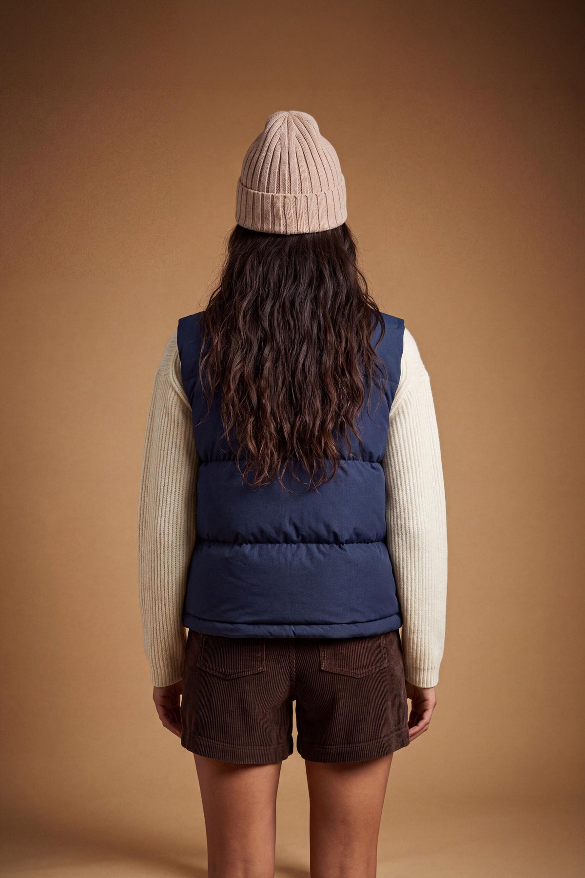 Women's nylon vest with polyamide lining and polyester padding, featuring horizontal quilting, high collar, zip closure, fleece-lined pockets, and adjustable hem for comfort. - Navy Blazer