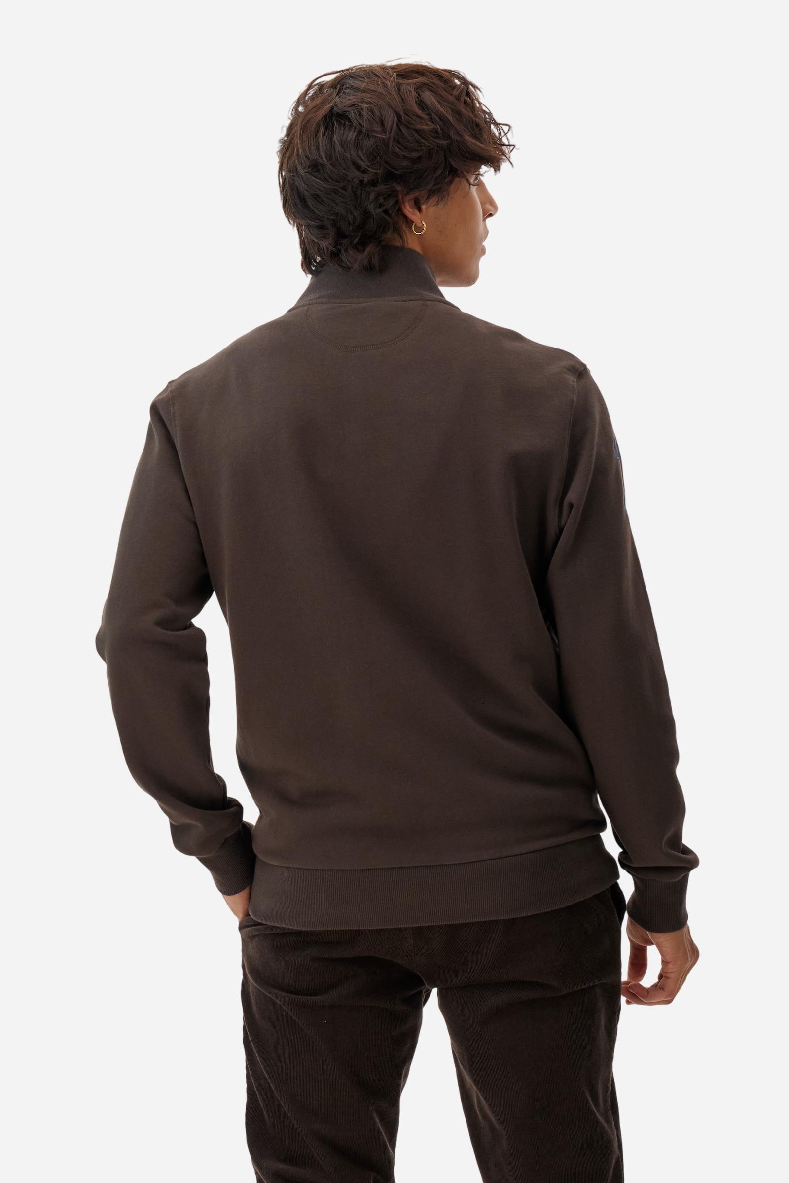 Men's long-sleeved solid colour sweatshirt. It is made of comfortable 100% cotton fleece with a soft-brushed feel. Model with high ribbed neck and front zip opening. Solid colour ribbed cuffs and waistband. The large contrasting brand team logo is embroidered on the chest. A contrasting colour fabric number patch is applied to the right sleeve. The model has a regular fit that offers a comfortable, relaxed silhouette. The model is wearing a size L. - Java