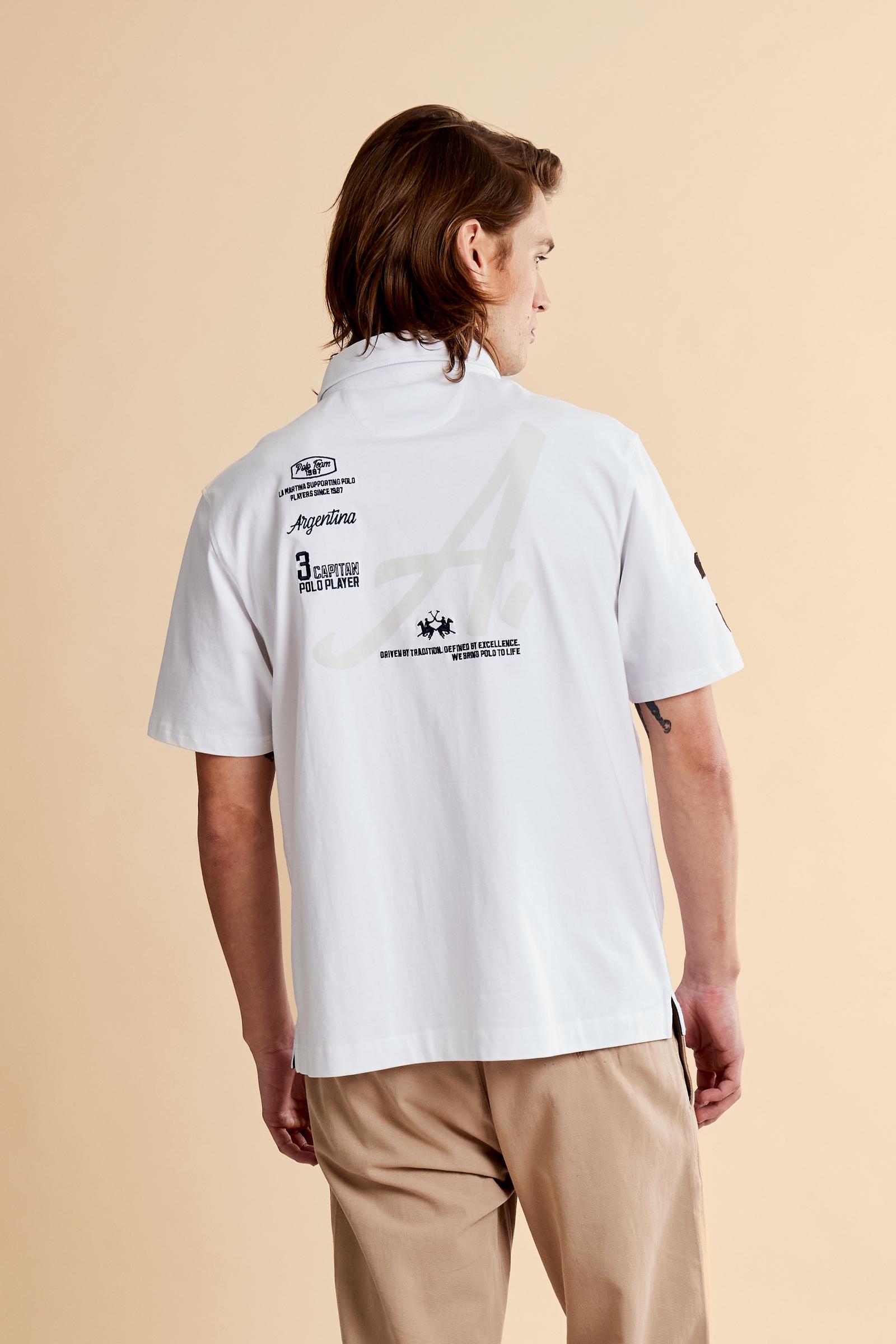 Men’s heavy cotton jersey polo with three-button placket and striped details. Celebratory maxi graphic and bold lettering. - Optic White                                                                                                                                                                                                                                                                                                                                                                                        