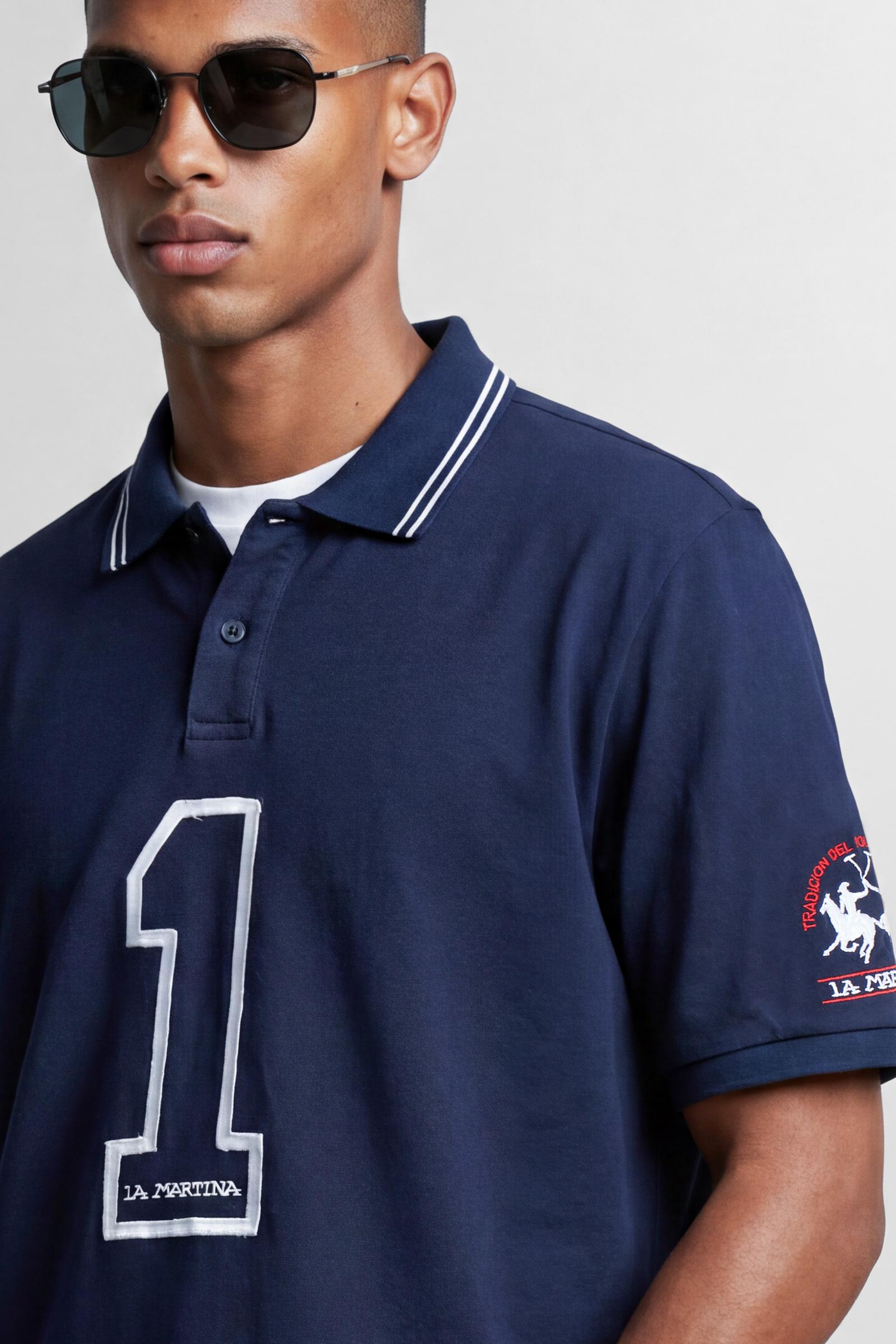 Numbered style with exclusive label, produced in only 100 pieces per style/colour. The label is positioned on the back, at the lower right, with the progressive number clearly visible. Short-sleeved polo shirt made from 100% cotton jersey. The contemporary-cut design features a modern, wide and relaxed silhouette, with a distinctly current streetwear touch. The collar is ribbed with contrast stripes, while the cuffs are ribbed tone-on-tone. The contrast number “1” on the chest, made from raw-edge finished f
