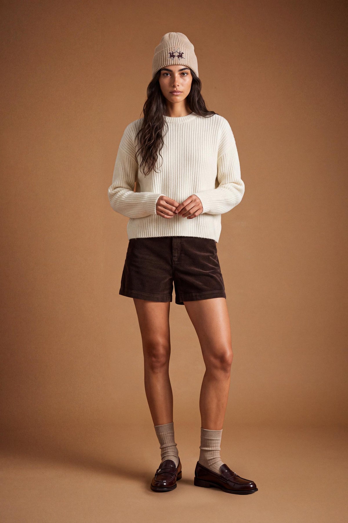 Soft lambswool women's sweater with vertical ribbed knit, relaxed fit, dropped shoulders, cropped length, and a subtle embroidered logo on the back neckline. - Antique White