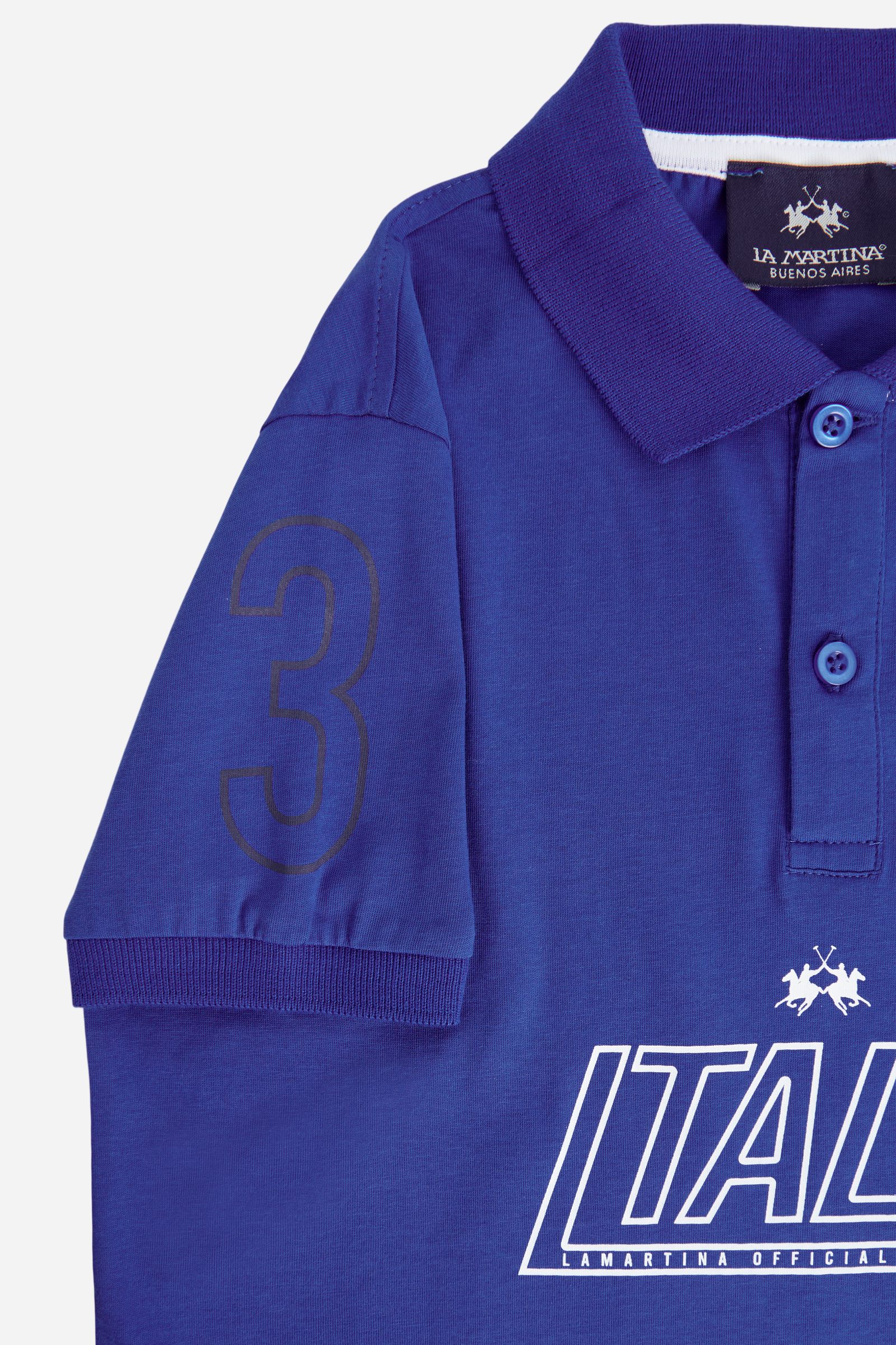 Short-sleeved polo shirt for boys made from 100% cotton jersey in a solid colour. The classic design features a ribbed collar and sleeve cuffs, a two-button front closure and contrast grosgrain tape inside the collar. Maxi lettering graphics on the front and back give the garment a bold look. The number “3” printed on the sleeve and the logo on the chest complete the style. - Surf The Web (Royal)