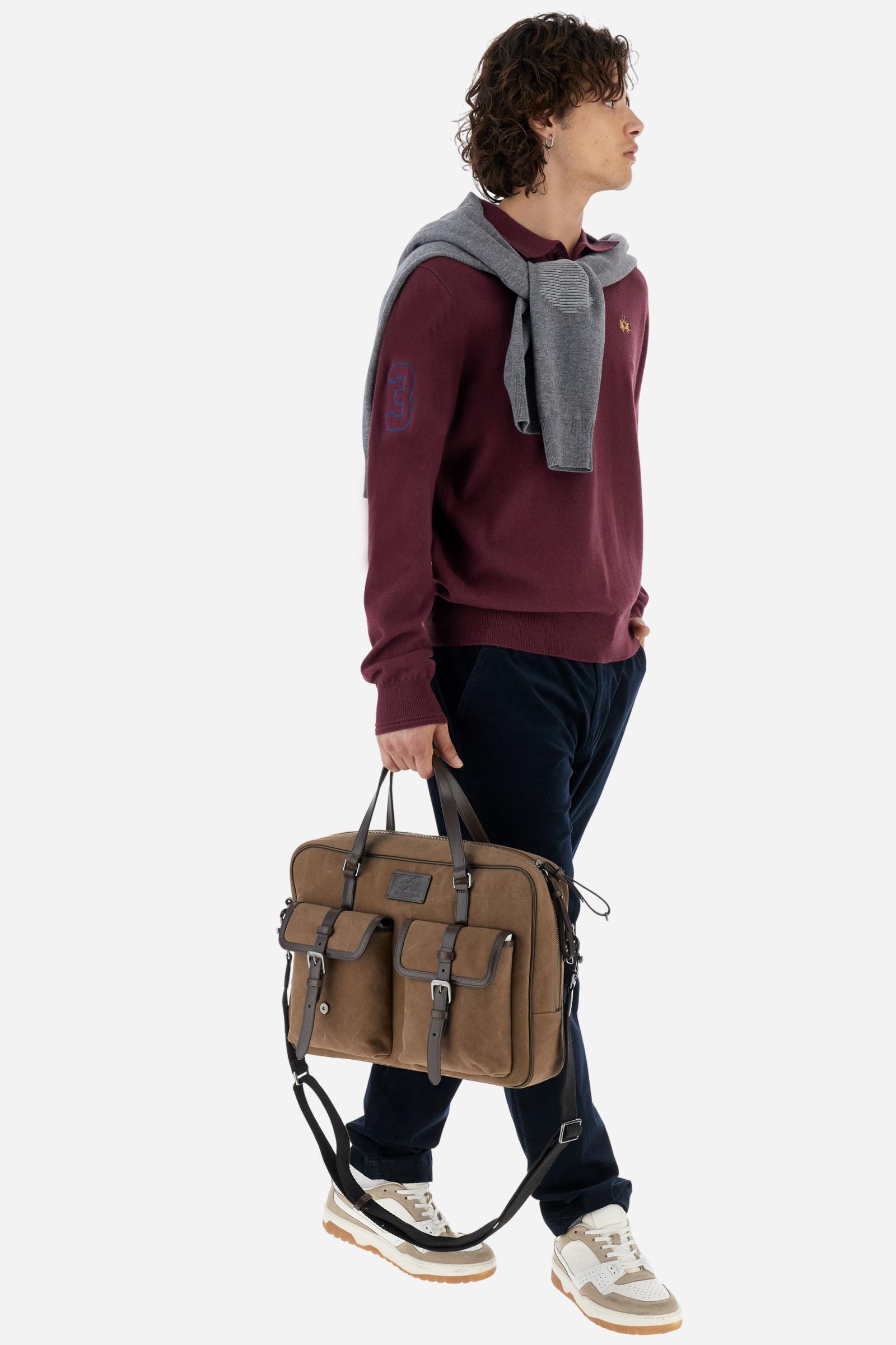 Men’s long-sleeved knitted polo in plain yarn blend (50% cotton, 50% wool), balancing comfort and warmth. Classic ribbed collar and cuffs with subtle contrasting stripe. Three personalized buttons on the placket. Small embroidered brand logo in contrasting color on the chest. On the right sleeve, a cord-embroidered number patch completes the design. Regular and slightly roomy fit. Model wears size L. - Port Royale