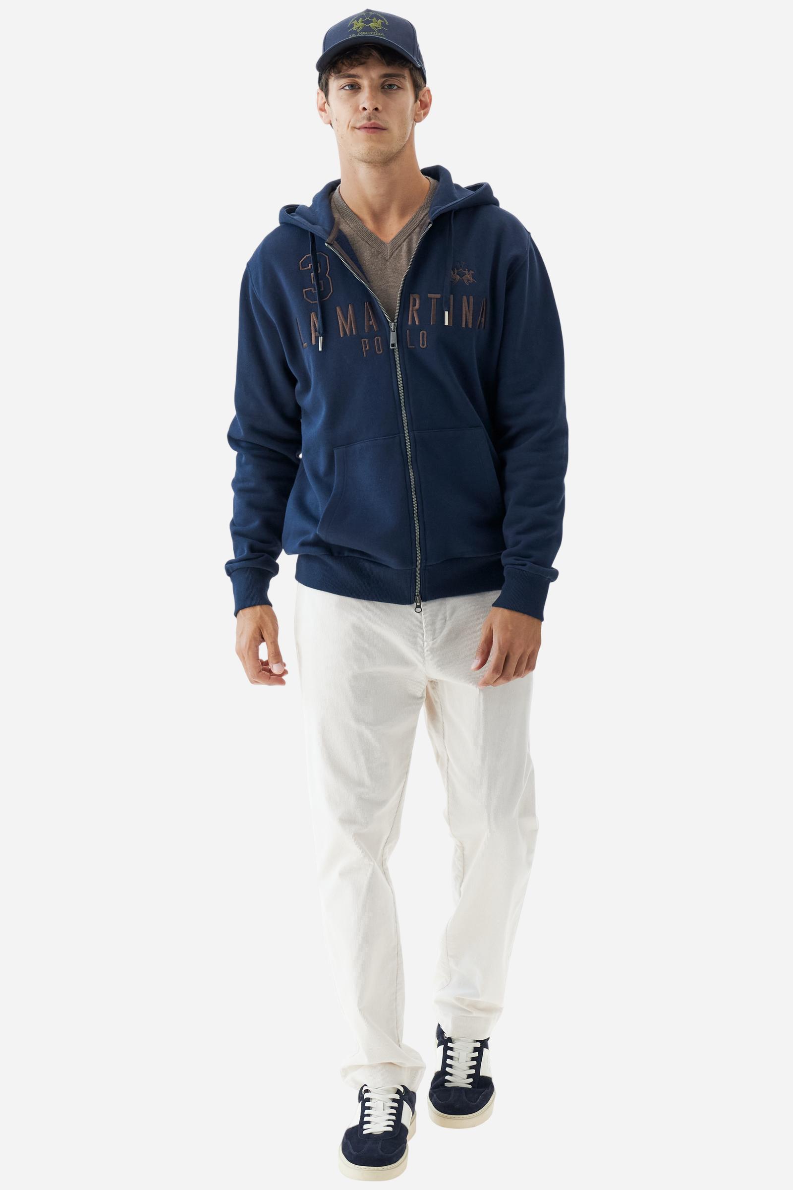 Men's long-sleeved hoodie in solid colour, made from soft 100% cotton fleece with a velvety touch. The model features a customised front zip and an adjustable hood with drawstring. Hem and cuffs in tone-on-tone rib. Iconic brand graphics stand out on the chest, embroidered with numbers and lettering. Regular fit ensuring comfort and freedom of movement. Model wears size L. - Navy