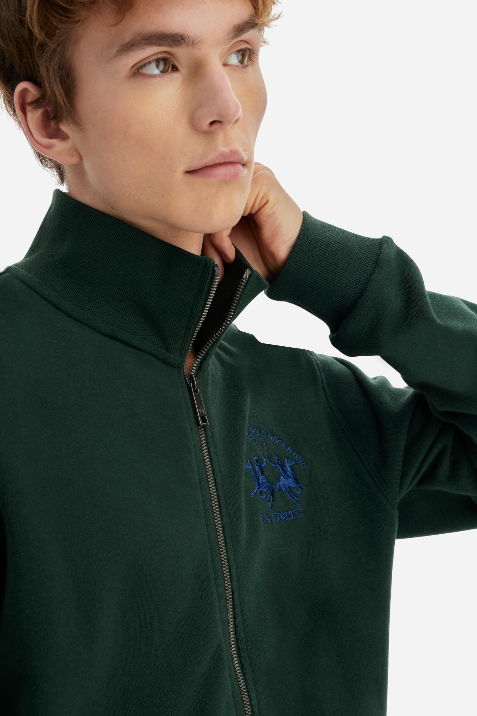 Men's long-sleeved solid colour sweatshirt. It is made of comfortable 100% cotton fleece with a soft-brushed feel. Model with high ribbed neck and front zip opening. Solid colour ribbed cuffs and waistband. The large contrasting brand team logo is embroidered on the chest. A contrasting colour fabric number patch is applied to the right sleeve. The model has a regular fit that offers a comfortable, relaxed silhouette. The model is wearing a size L. - Sycamore