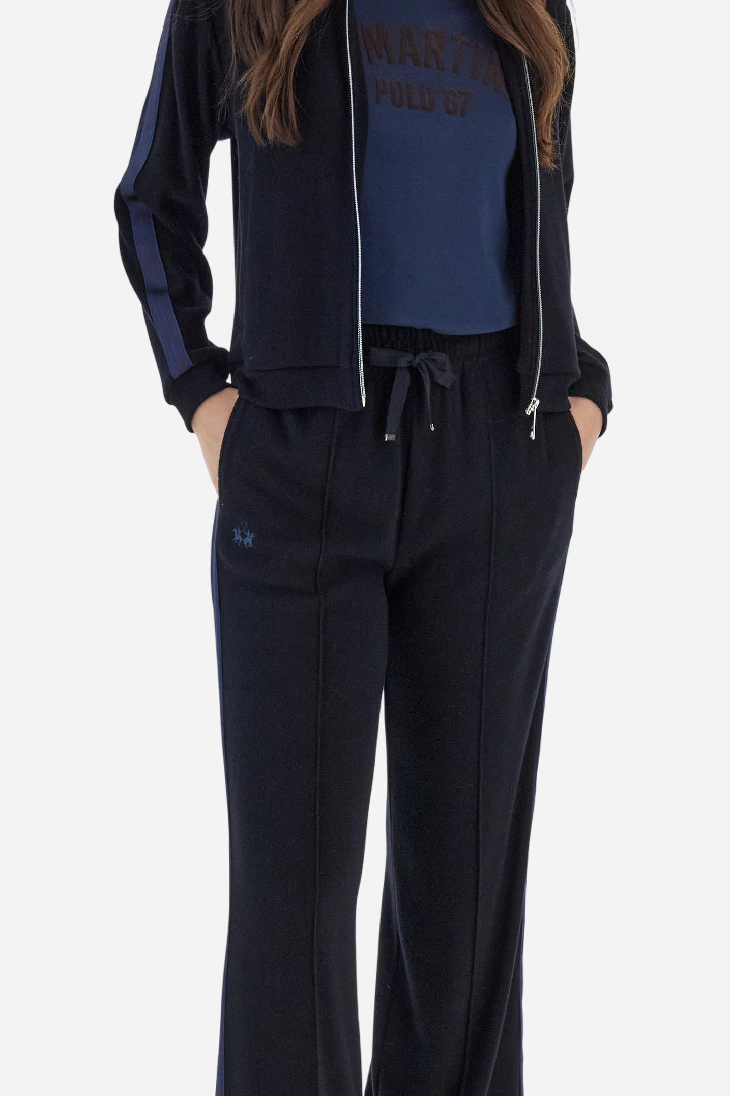 Women’s pants made of viscose-blend interlock fleece, soft and luxurious on the skin. Elastic waistband with adjustable drawstring ensures optimal comfort. Side pockets and bicolor striped tape along the sides complete the design. A small tonal embroidered logo enriches the front. Straight leg with slightly flared hem for a feminine, elegant twist in athleisure style. Model wears size 2. - Navy