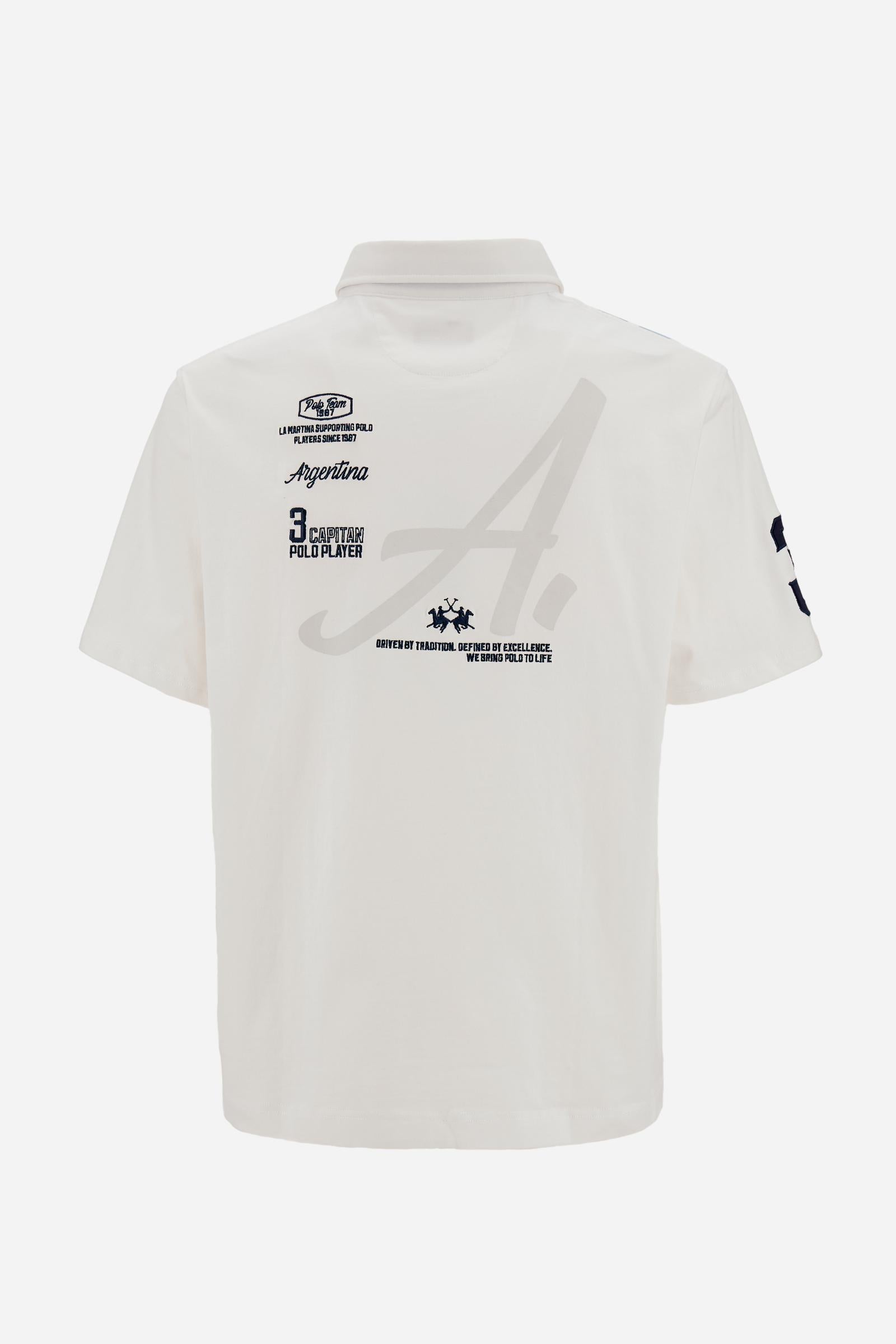 Men’s heavy cotton jersey polo with three-button placket and striped details. Celebratory maxi graphic and bold lettering. - Optic White                                                                                                                                                                                                                                                                                                                                                                                        